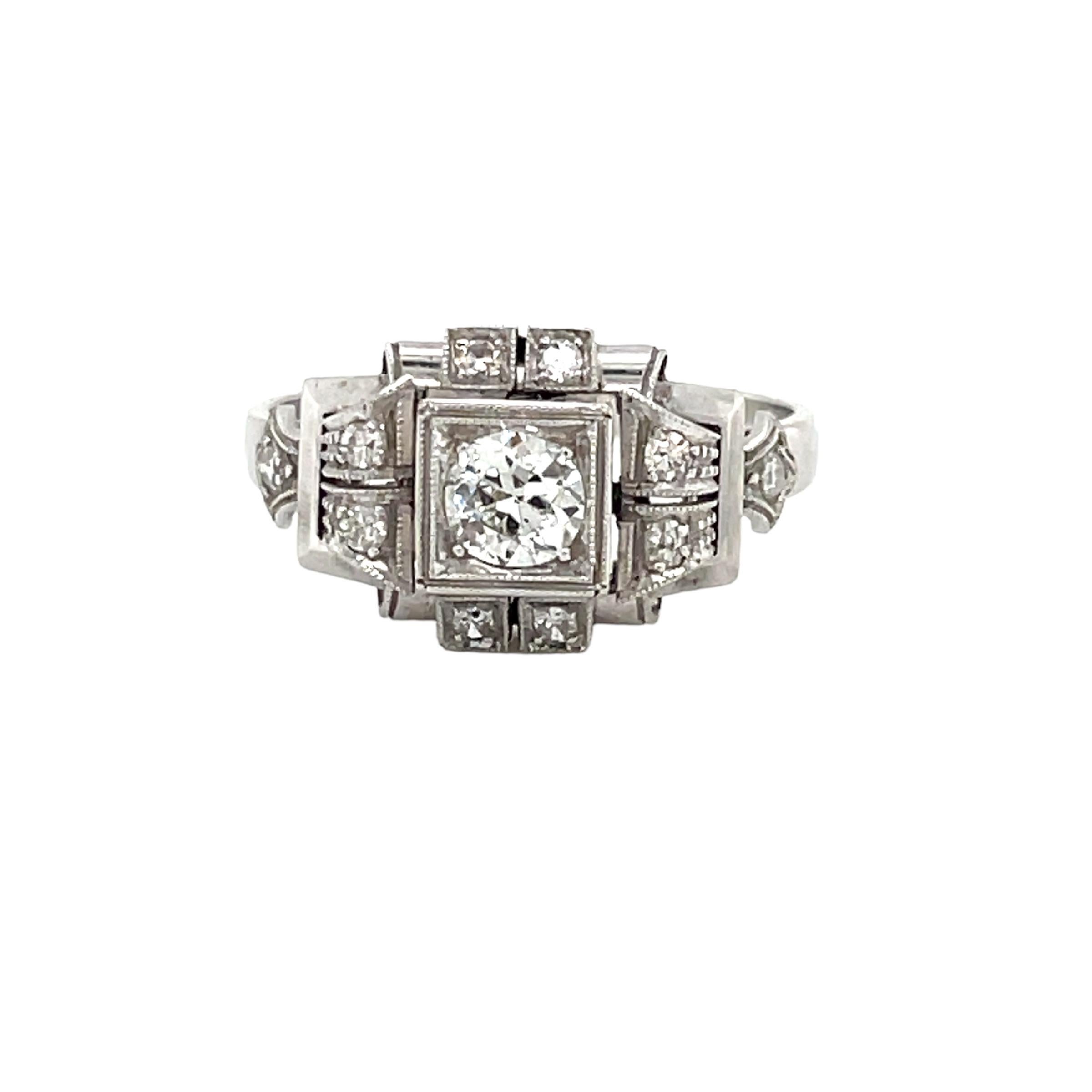 An exquisite Art Deco ring, hand-crafted in 18k white gold, authentic from 1930, featuring in the center sparkling Old mine-cut Diamond weighing .50 carat, surrounded by 0,30 carats of smaller diamonds.

The ring is original in every part and it