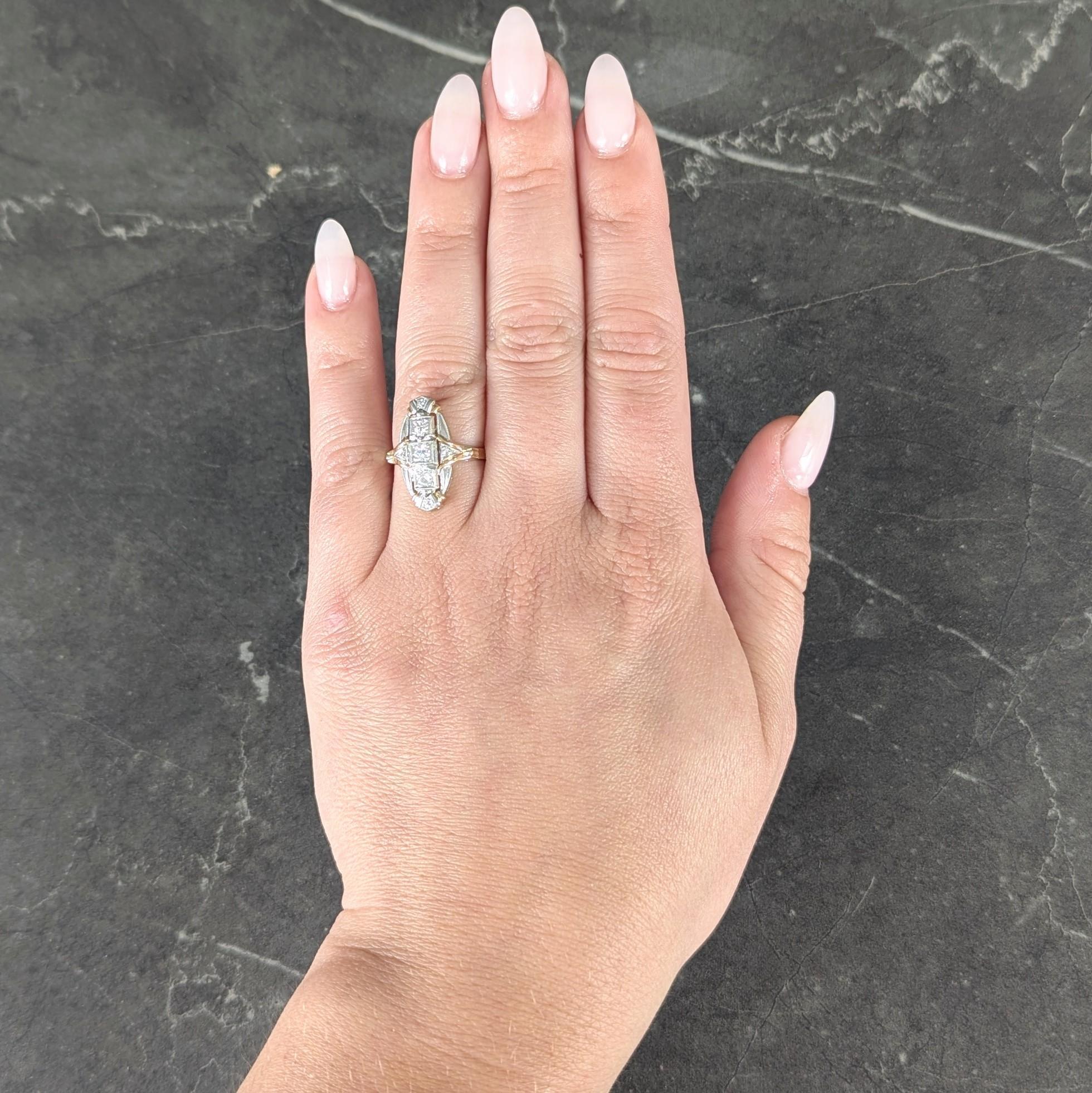 Kopf in Form einer Navette mit einem durchbrochenen und mit Platin überzogenen Stromlinienmotiv
Drei alte Diamanten mit europäischem Schliff in der Mitte, von Norden nach Süden gefasst
Mit zusätzlichen Diamanten in den Himmelsrichtungen
Mit einem