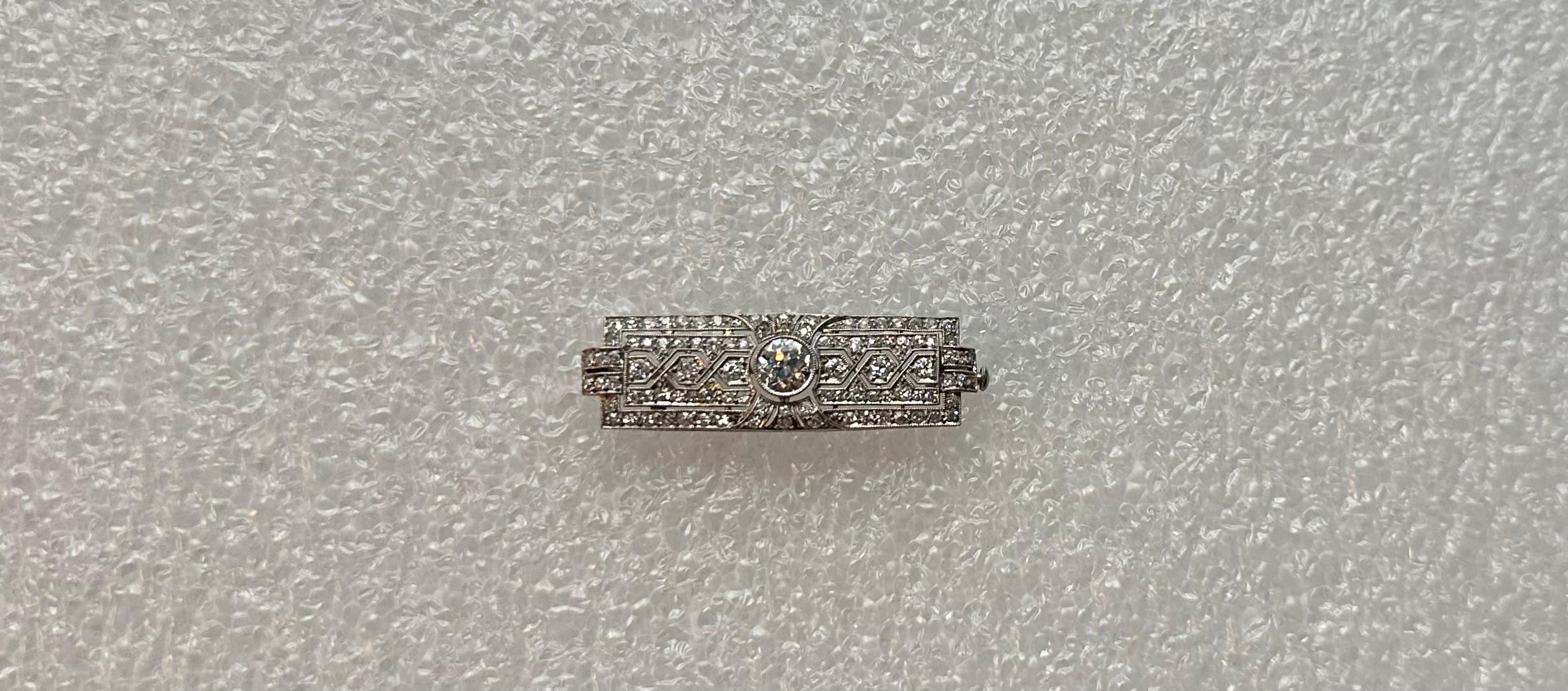 This vintage stunning Art Deco diamond brooch is exceptionally designed in a platinum setting showcasing a magnificent sparkling one carat (F/vvs/vs) faceted diamond center. An array of ninety-four dazzling diamonds in various sizes surround &