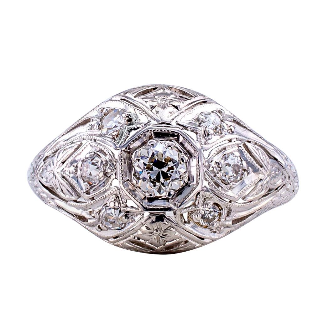 Art Deco diamond and platinum ring circa 1925. The slightly domed design is set at equal intervals with seven round diamonds totaling approximately 0.40 carat, approximately I – K color and VS – SI clarity, on a platinum mounting lavishly decorated