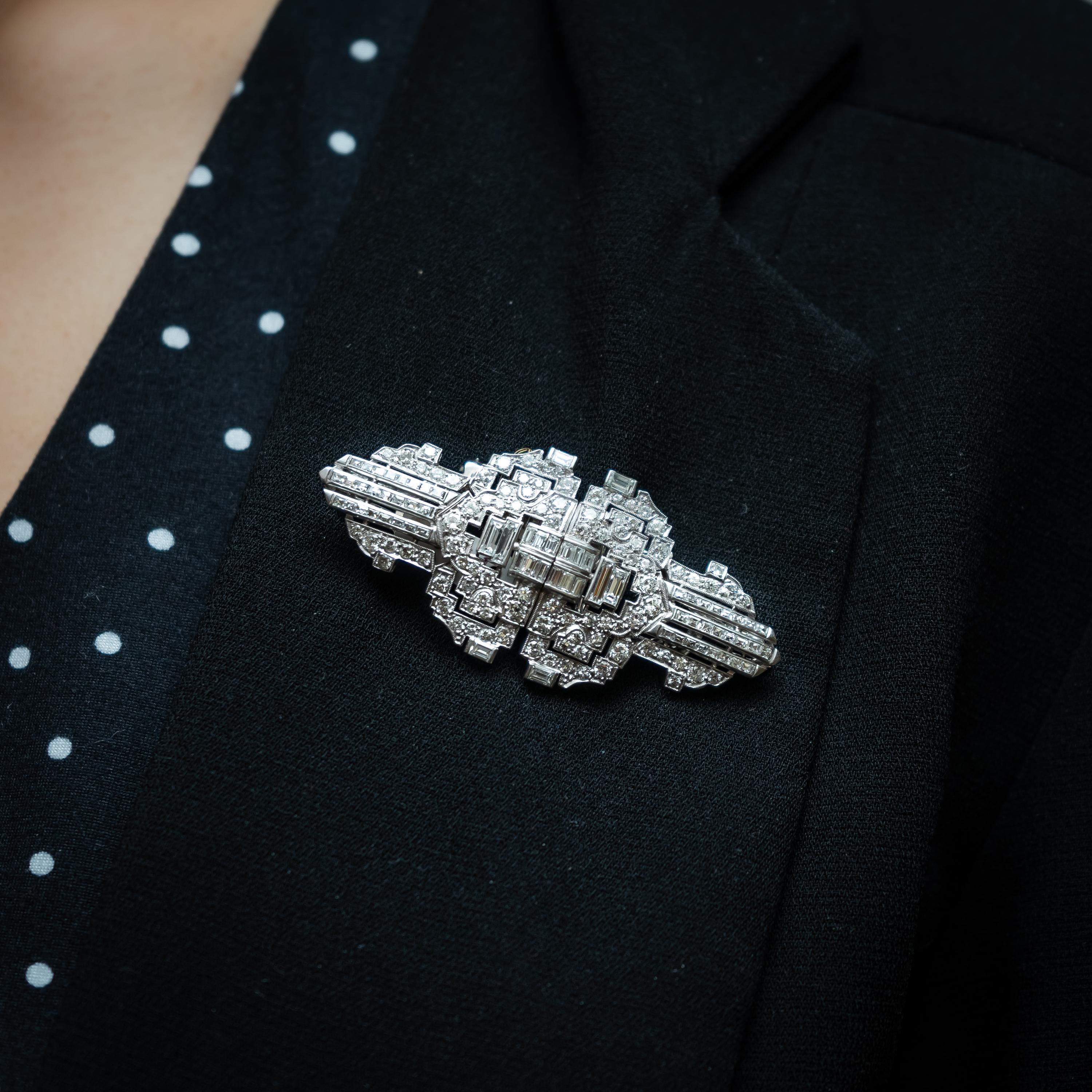 An Art Deco diamond double clip brooch, set with approximately 7.00ct of round brilliant-cut and baguette-cut diamonds, mounted in platinum with white gold fittings, measuring approximately 6.2 x 2.7cm, circa 1930.