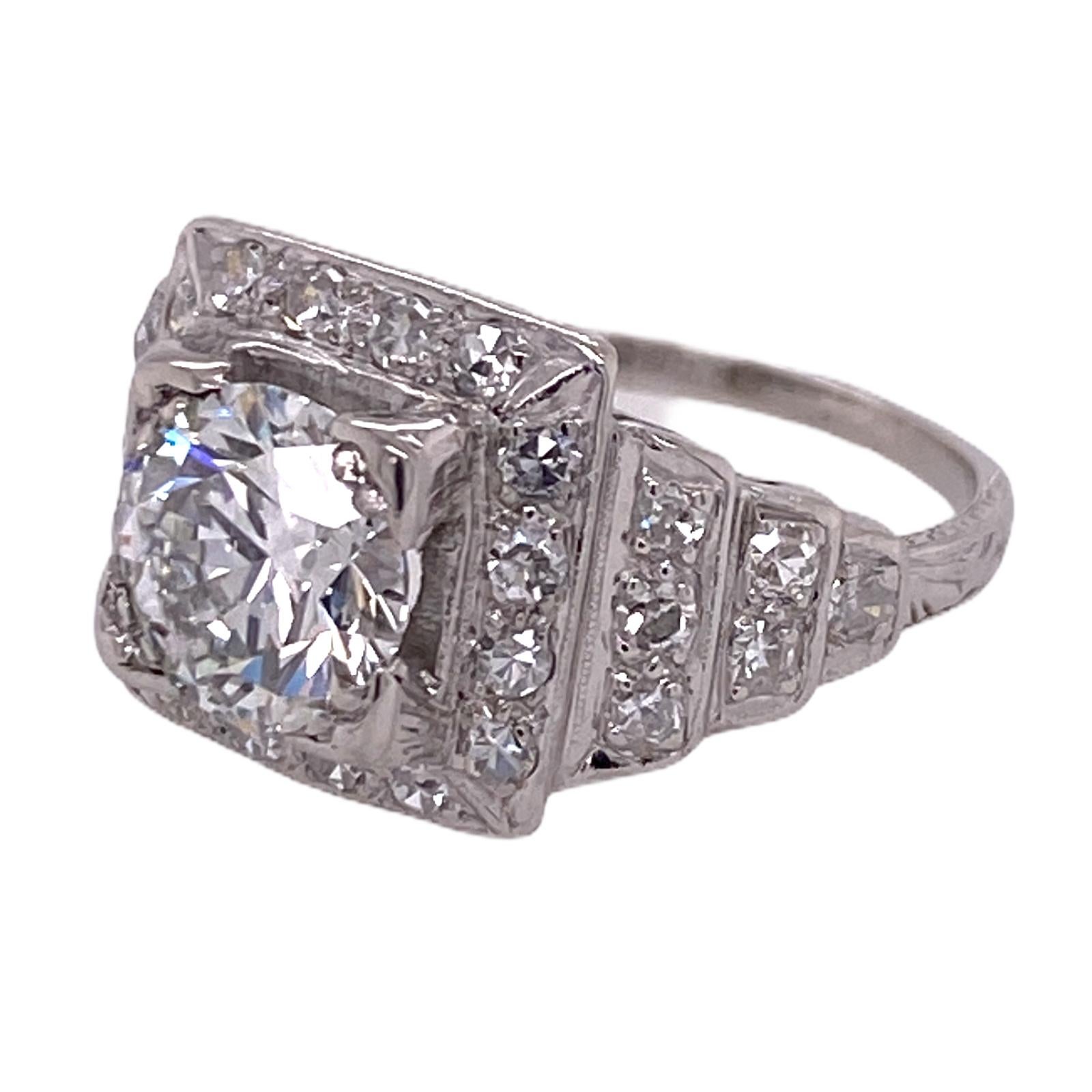 Gorgeous Art Deco diamond engagement ring handmade in platinum. The center Old European cut diamond weighs 1.36 carats and is graded J color and SI1 clarity by the GIA. The Art Deco mounting features 28 single cut diamonds weighing approximately