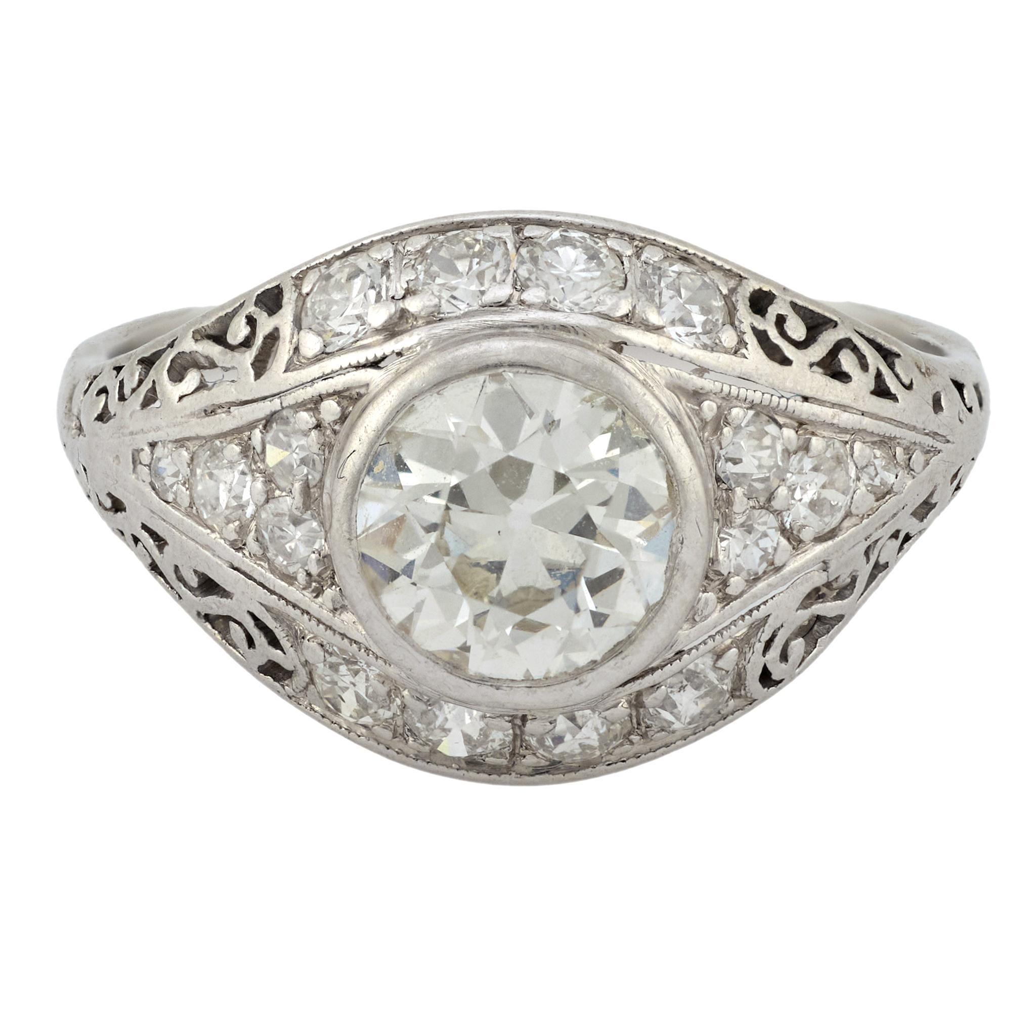 Este elegante anillo Art Déco de los años 30 se centra en un brillante diamante de talla europea antigua de 0,80 quilates, con calidez de color J y nítida claridad VS. Dieciséis piedras de acento -antiguos diamantes europeos y de talla única que