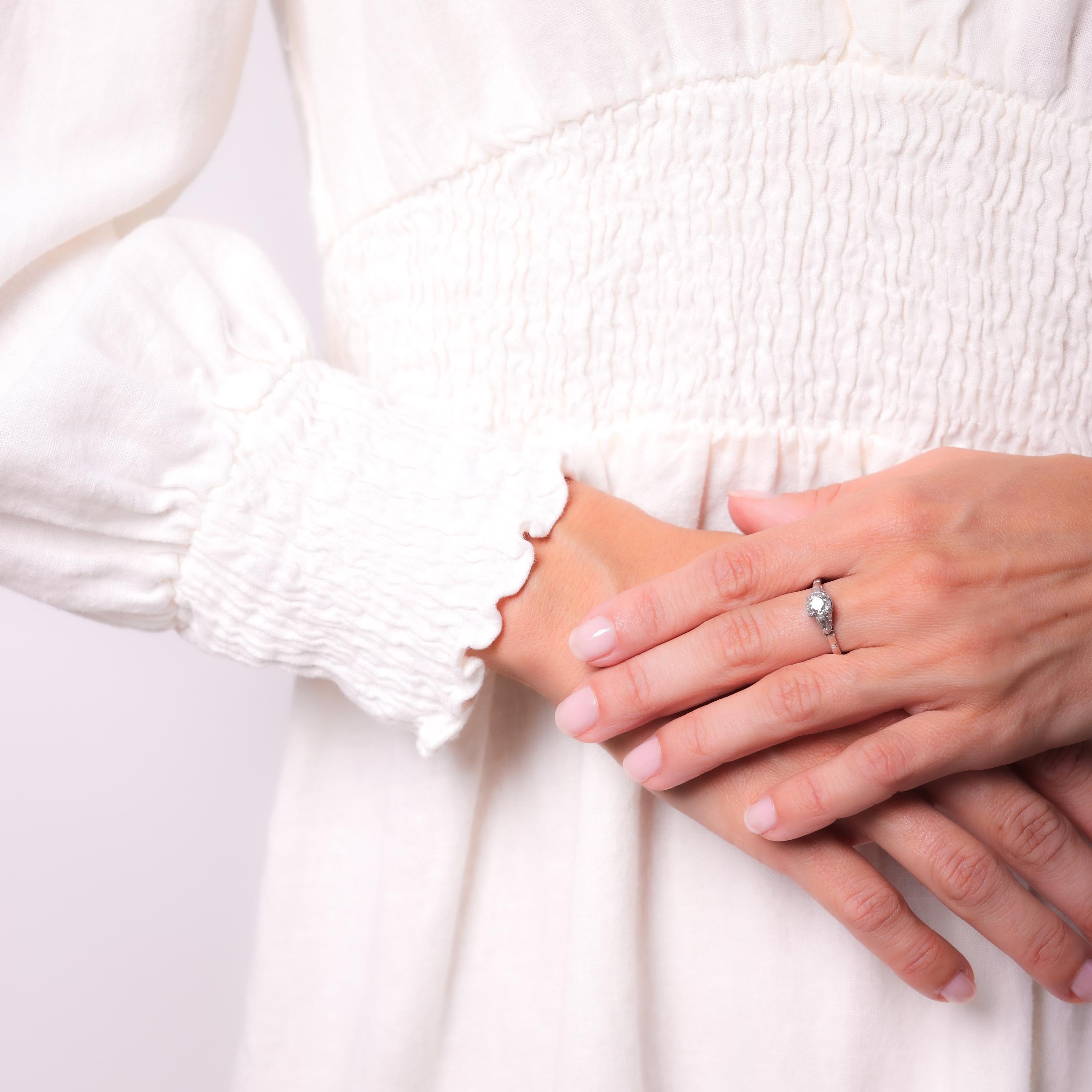 Pierre centrale : Diamant de taille européenne ancienne
Poids : Environ 0,86 carat
Couleur : N
Clarté : SI1
Pierre d'accentuation : 2 diamants taille baguette et 8 diamants taille ancienne européenne
Poids : Environ .30 Carats
Couleur : H
Clarté :