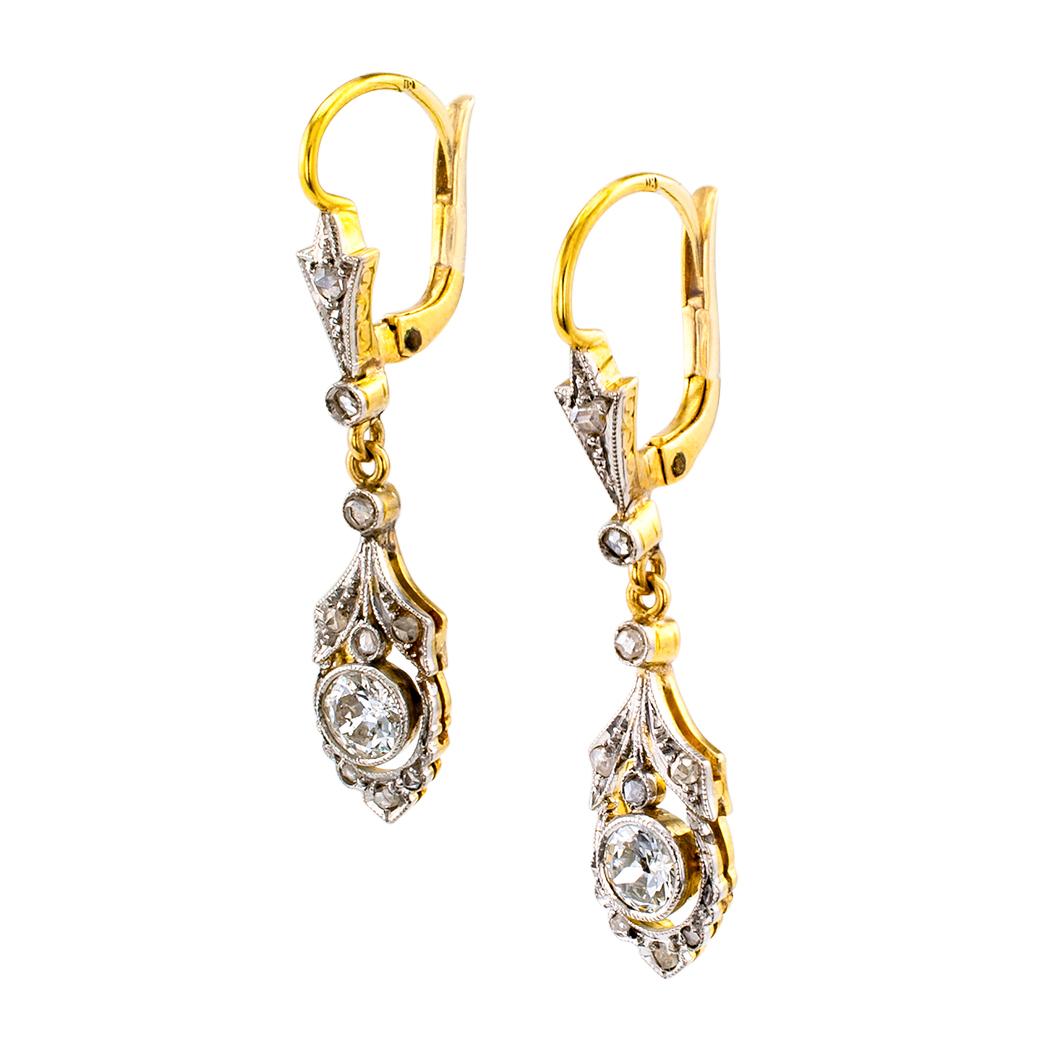 Art Deco diamond platinum and gold drop earrings circa 1930. The articulated, open work designs are set throughout with diamonds totaling approximately 0.65 carat, approximately H – K color and SI – I clarity, mounted in platinum over 18-karat