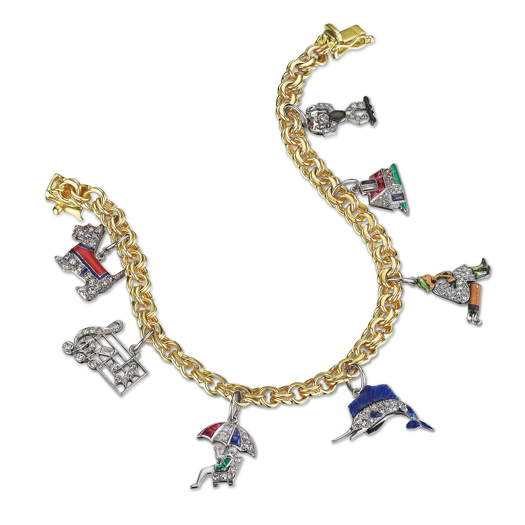 Charm yourself!  This seven charm Art Deco, circa 1920-1940, bracelet is simply enchanting.  Each whimsical platinum gemstone charm delicately dances from a 14 karat yellow gold link bracelet and is guaranteed to make you smile.  Selection of