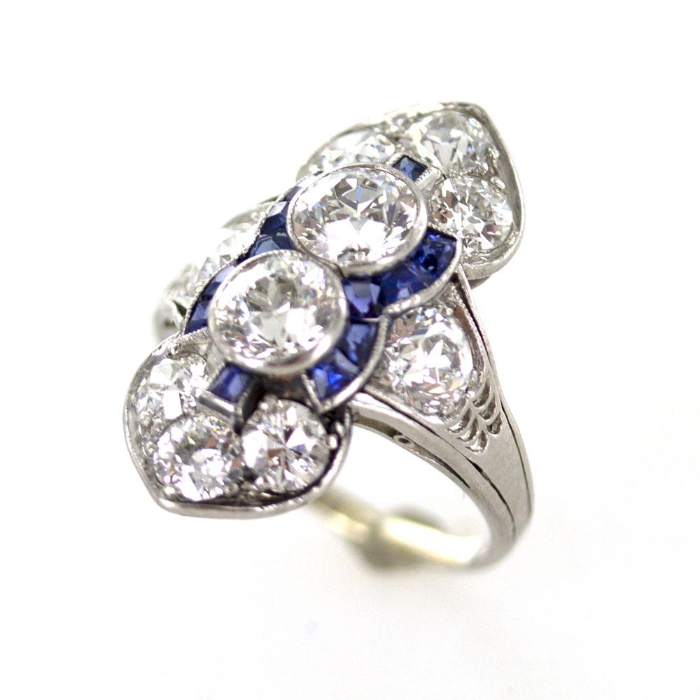 This stunning Art Deco cocktail ring is circa 1920's. The ring features two large center Old European Cut diamonds (1.50 carat total weight), and another 2.50 carats of side diamonds. The bright diamonds are graded H-I color and VS clarity. Hand