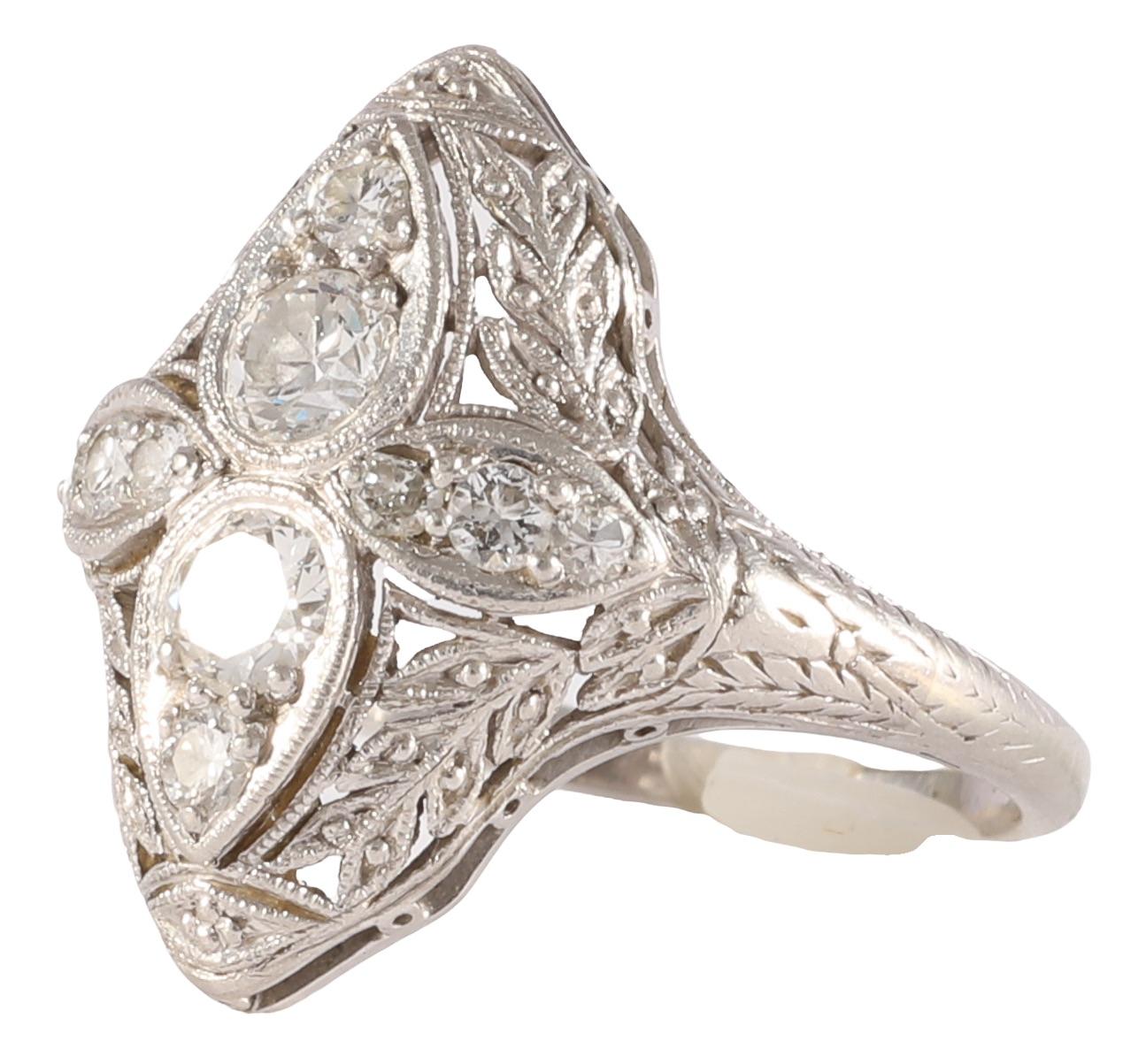 Art Deco diamond platinum ring that features near colorless Old European diamonds and a beautiful floral engraving. The elongated shape offer more finger coverage than expected with a less than one carat diamond ring. Timeless elegance in a