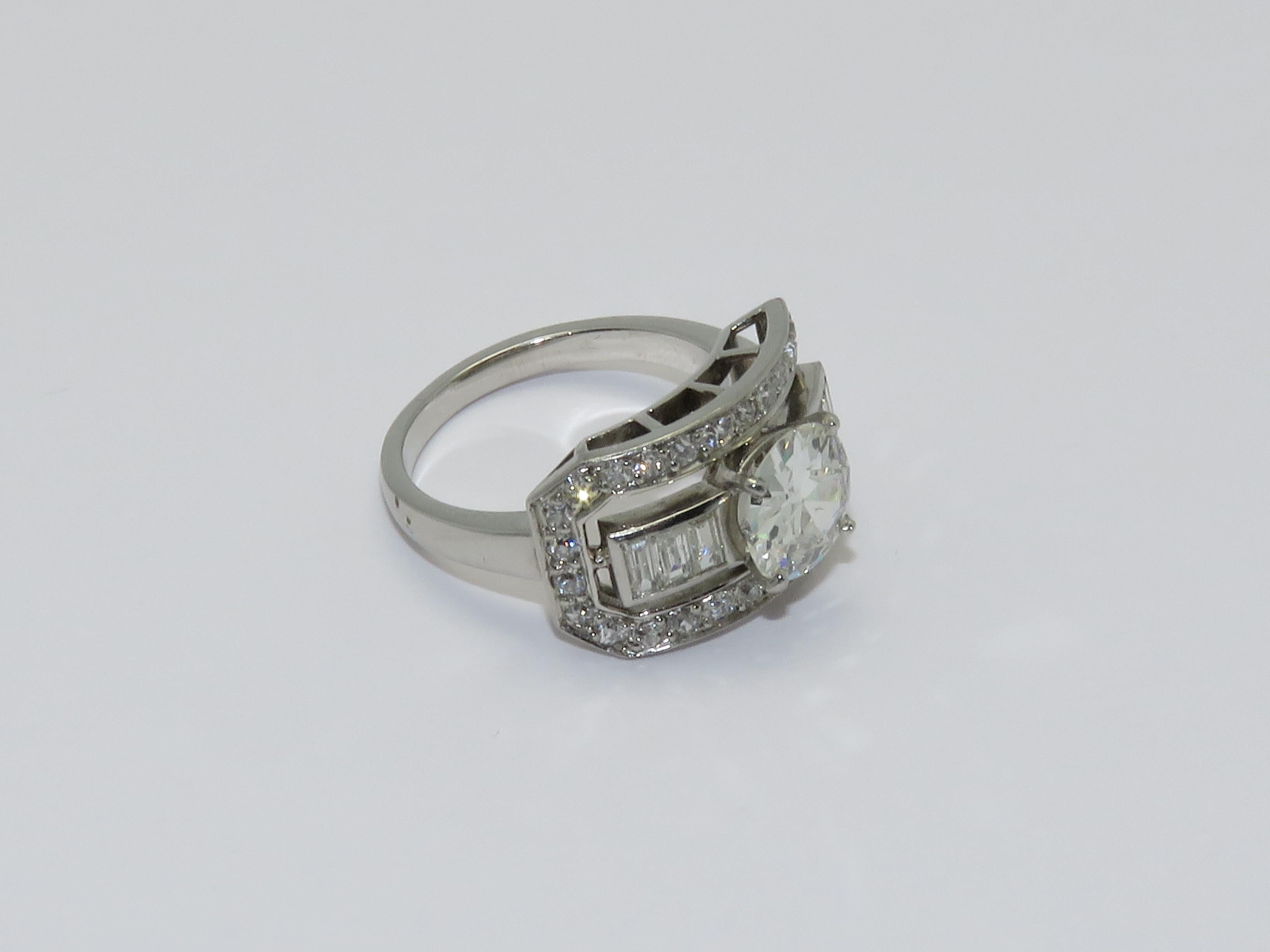 A platinum ring set with one central round old cut diamond in a claw setting 
with square surround with approximate weight 1.20 carat 
and baguette cut diamonds and round diamonds

Ring Size 50           5 1/4 US

Measurements
Height: 0.51 in ( 1.30