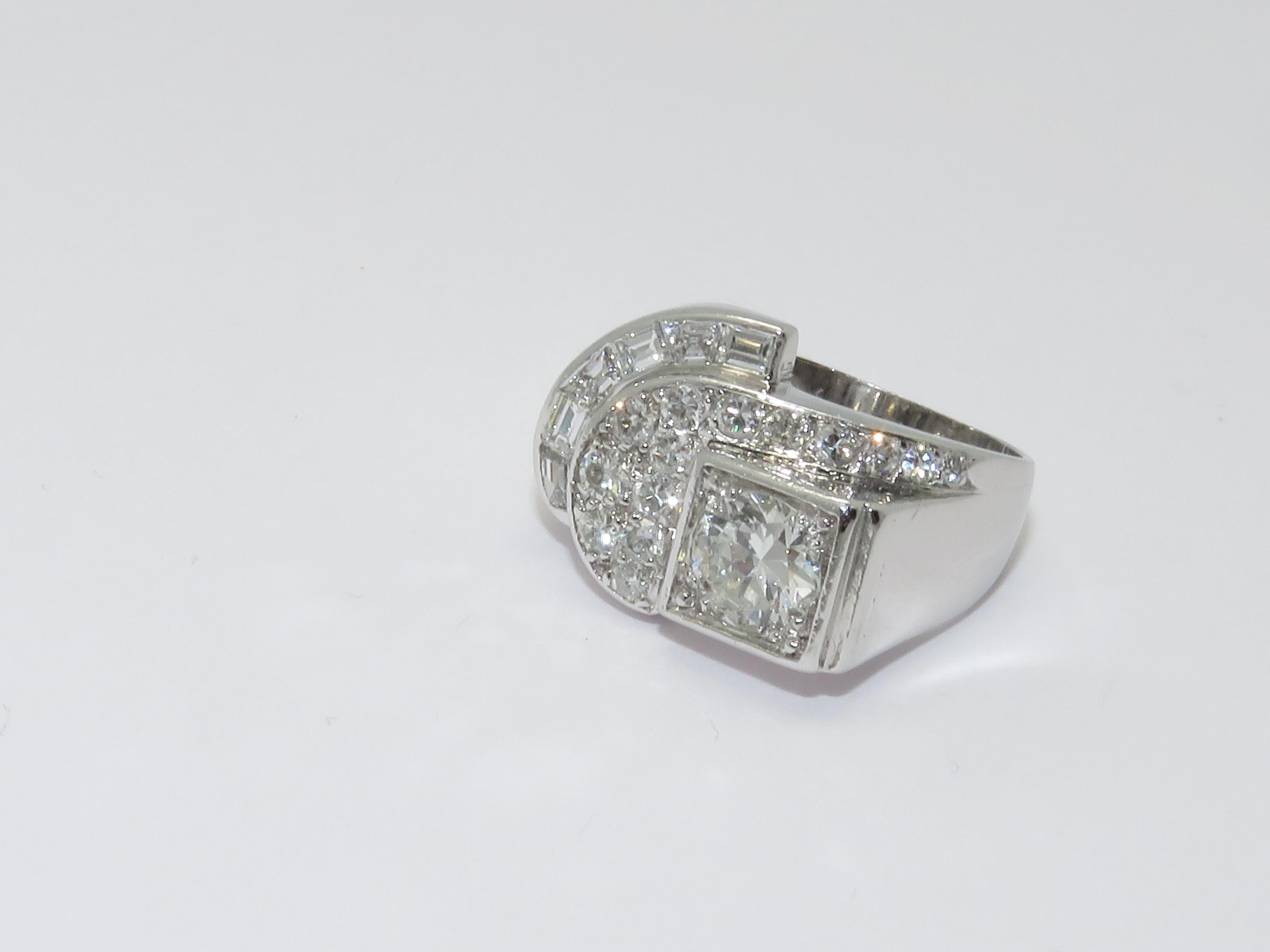 A platinum ring set with one central round old cut diamond in a claw setting 
with square surround with approximate weight 1 carat 
and baguette cut diamonds and round diamonds total carat weight approximately 1.50 carat.

Ring Size 53           6
