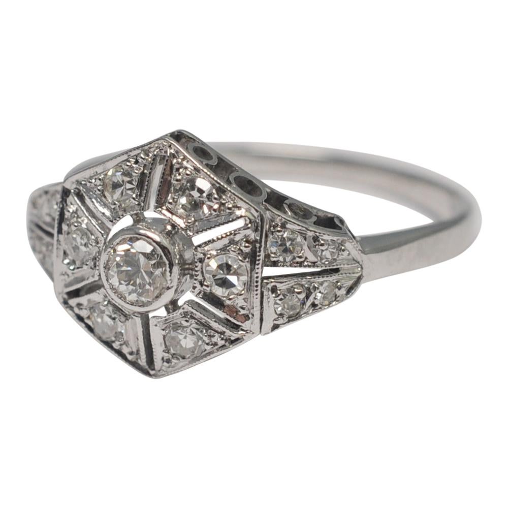 Art Deco platinum and diamond vintage engagement ring;  this pretty ring is set with a central Transitional cut, bezel set,  diamond surrounded by 6 sections of 8-cut diamonds.  The diamond sections and shoulders are all in millegrain and the under