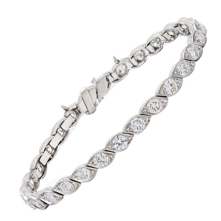 Curved links contain a total of approximately 5.60 carats of old European cut diamonds mounted in platinum. The bracelet is 7 inches long and 3/16 inch wide.