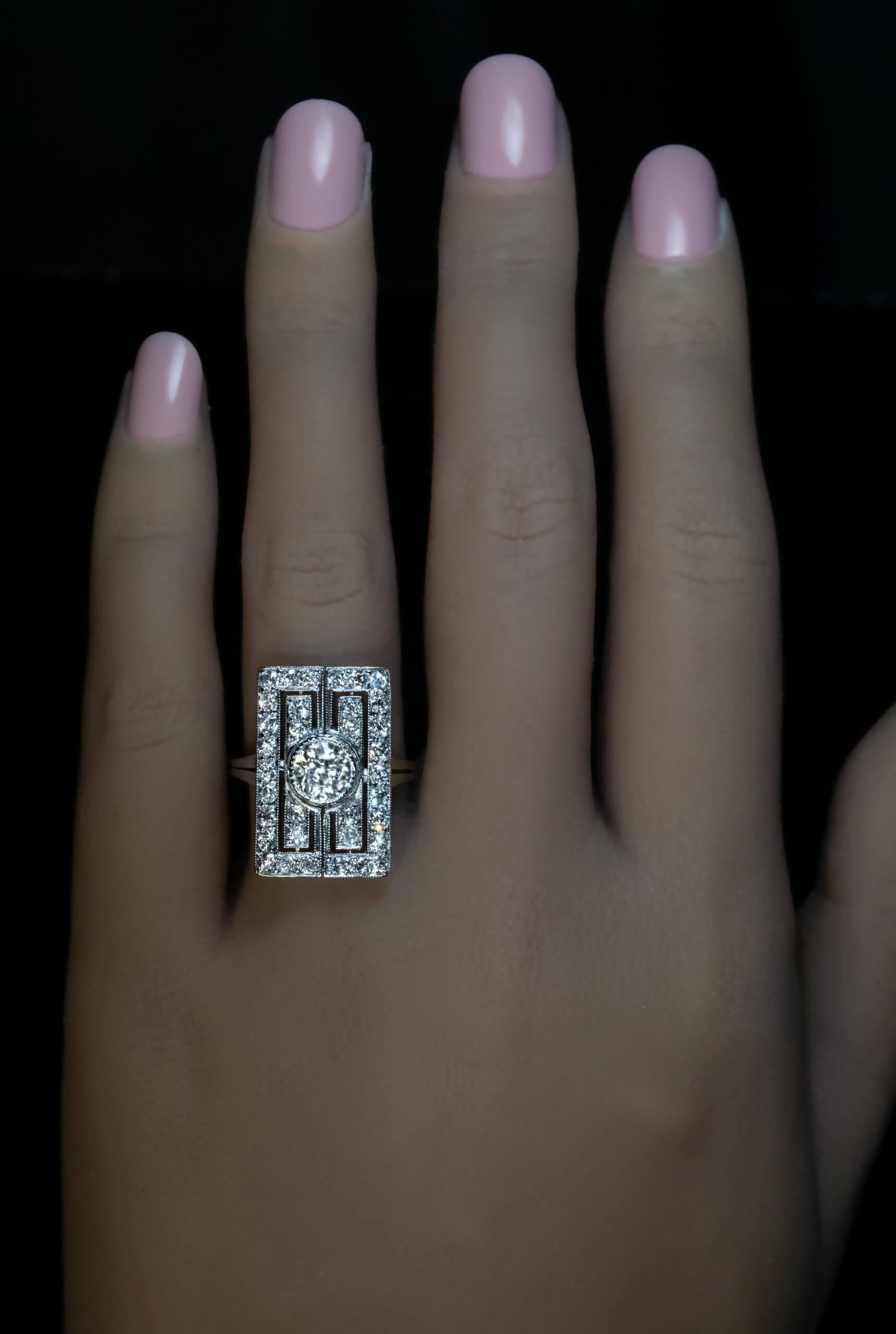Circa 1925  This Art Deco era ring of a unique geometric design is finely crafted in platinum. It features a 1.17 carat Old European cut diamond (I color, VS2 clarity) framed by numerous small old cut diamonds.  Estimated total diamond weight is
