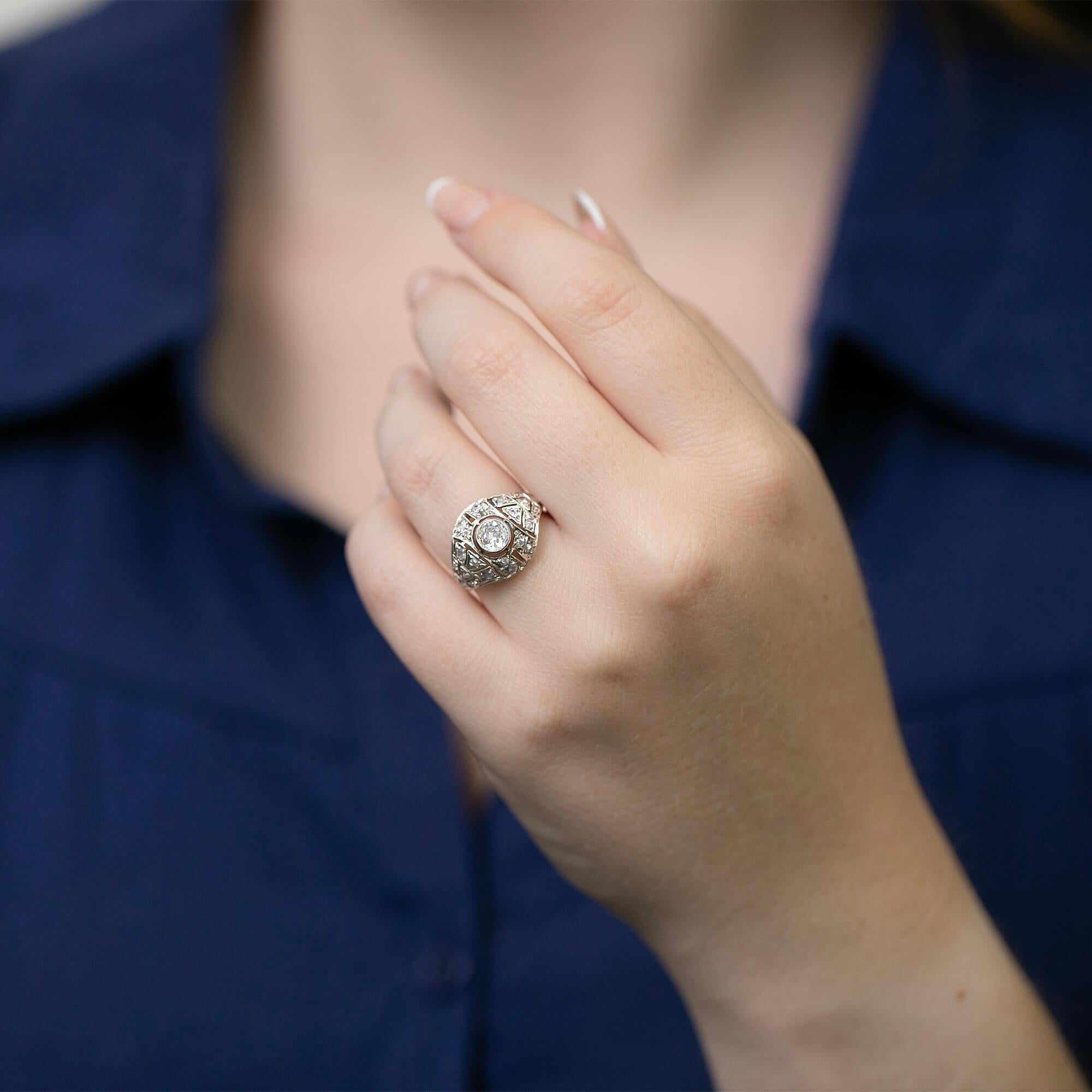 True to its era this Art Deco diamond ring is crafted in platinum and features a domed setting with a geometric saw pierced, mille-grained and bezel settings set with a beautiful old mine and rose cut diamonds. Hand-made by a USA