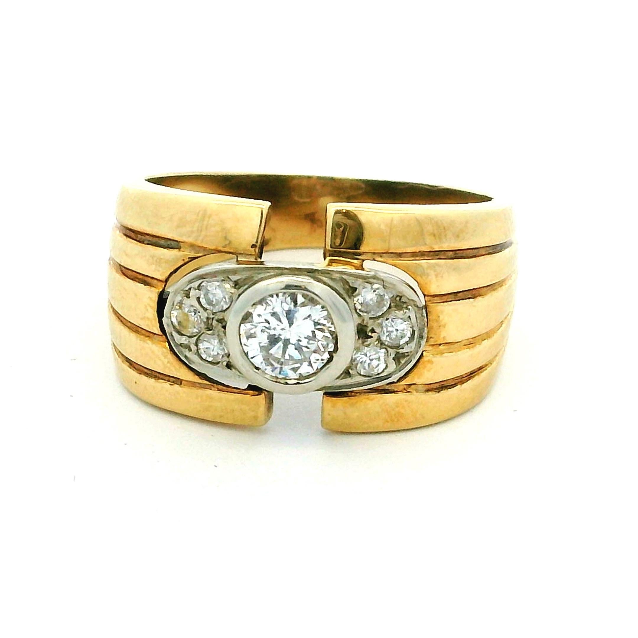 Este anillo de los años 30, una belleza arquitectónica de la época Art Decó, combina una audaz geometría con un brillo intemporal. Realizado en oro amarillo de 14 quilates con engaste de platino, presenta un diamante central talla brillante de