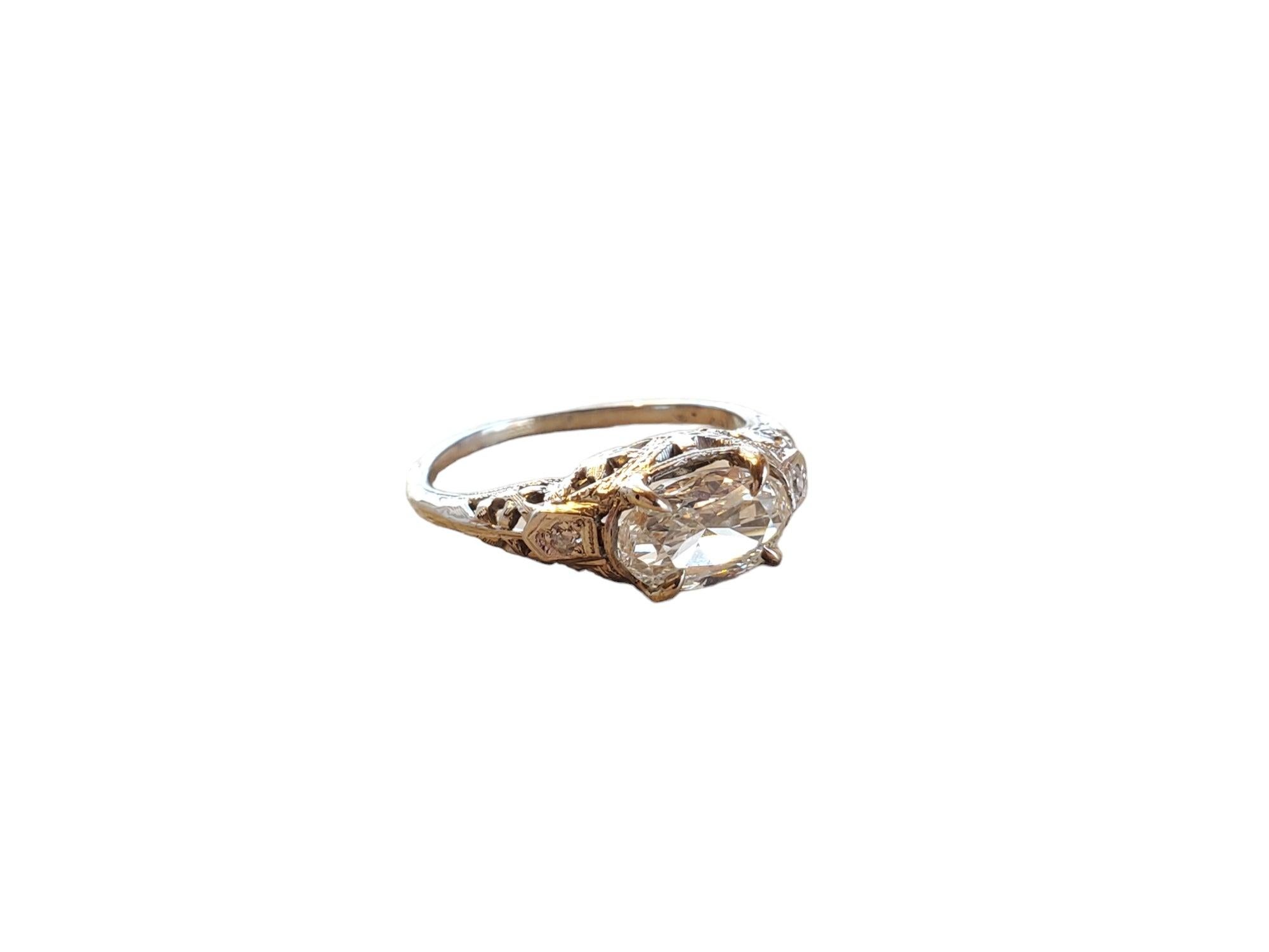 This listing is for an art deco 18k wg oval diamond ring. The center stone is a gorgeous older oval set east/west and weighing .90ct with 2 accent diamonds. The stone is very clean and white facing with a tiny bit of warmth. Size is 5.75