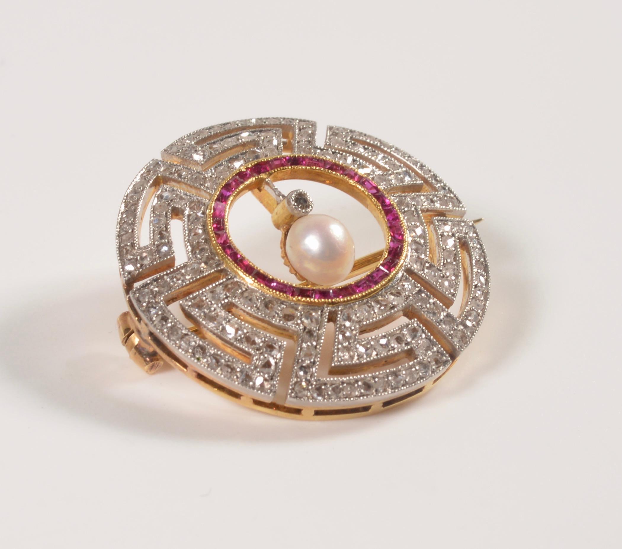 Classical and stylish Art Deco diamond and ruby brooch of exceptional quality suspending a cultured pearl, framed by rose-cut diamonds and channel-set rubies, platinum-topped gold Greek key geometric mount. From the collection of Edith Weber Antique