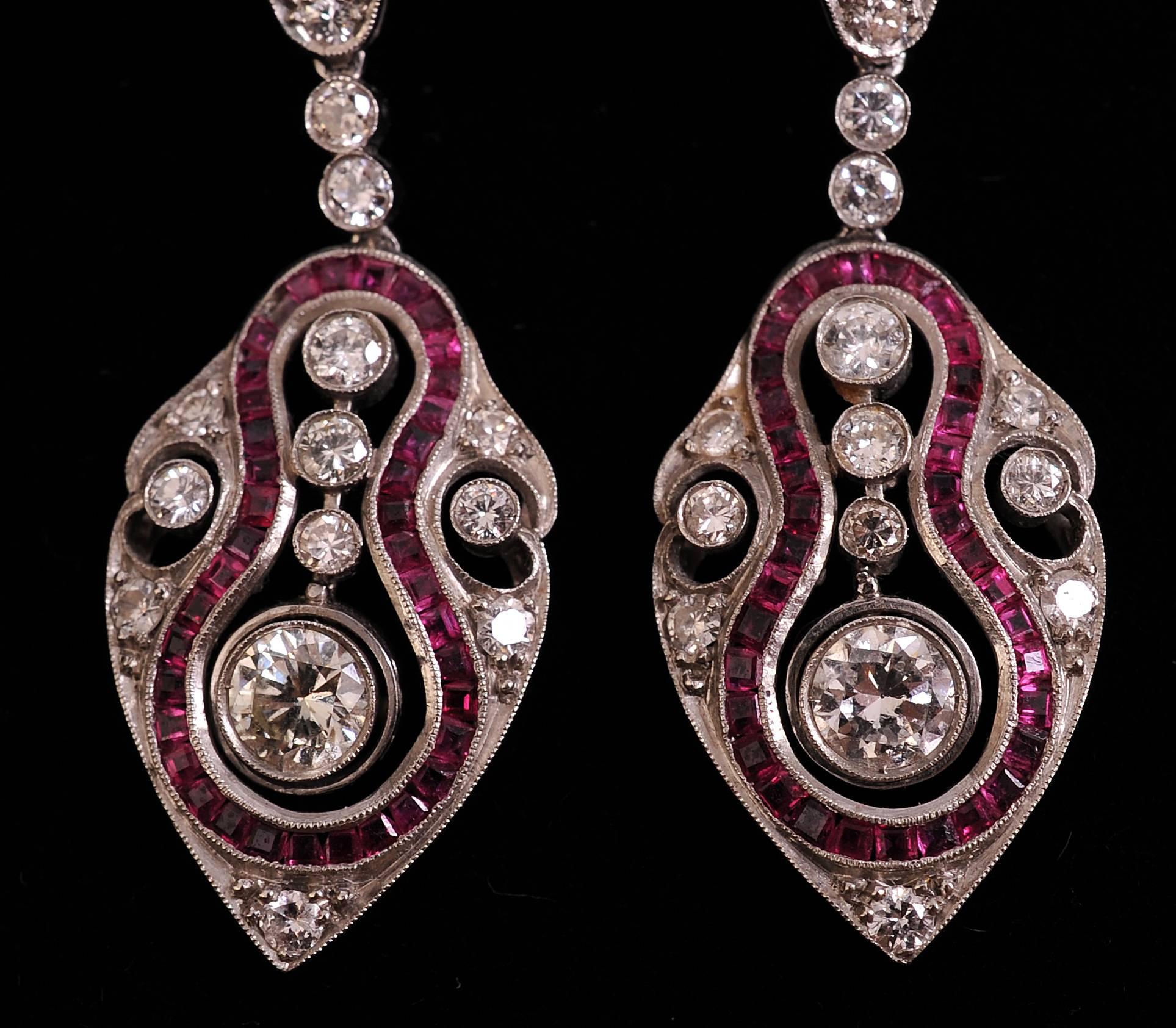 This is a stunning pair of Art Deco diamond, ruby and platinum earrings with the central .50 carat diamonds en tremblant. The earrings are composed of old European cut diamonds and baguette cut rubies and they suspended from gold wires. They are in