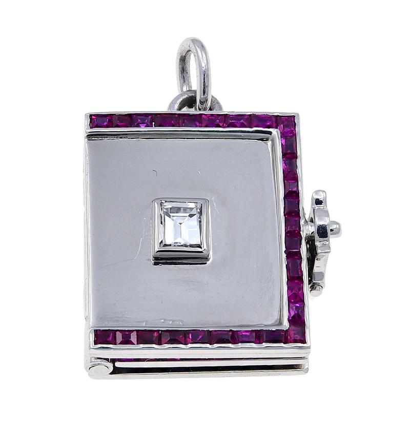 A jewel:  a figural platinum book, set with a center emerald cut diamond.  The border is comprised of calibre cut rubies which have exceptional brilliant color.  Inside are three 