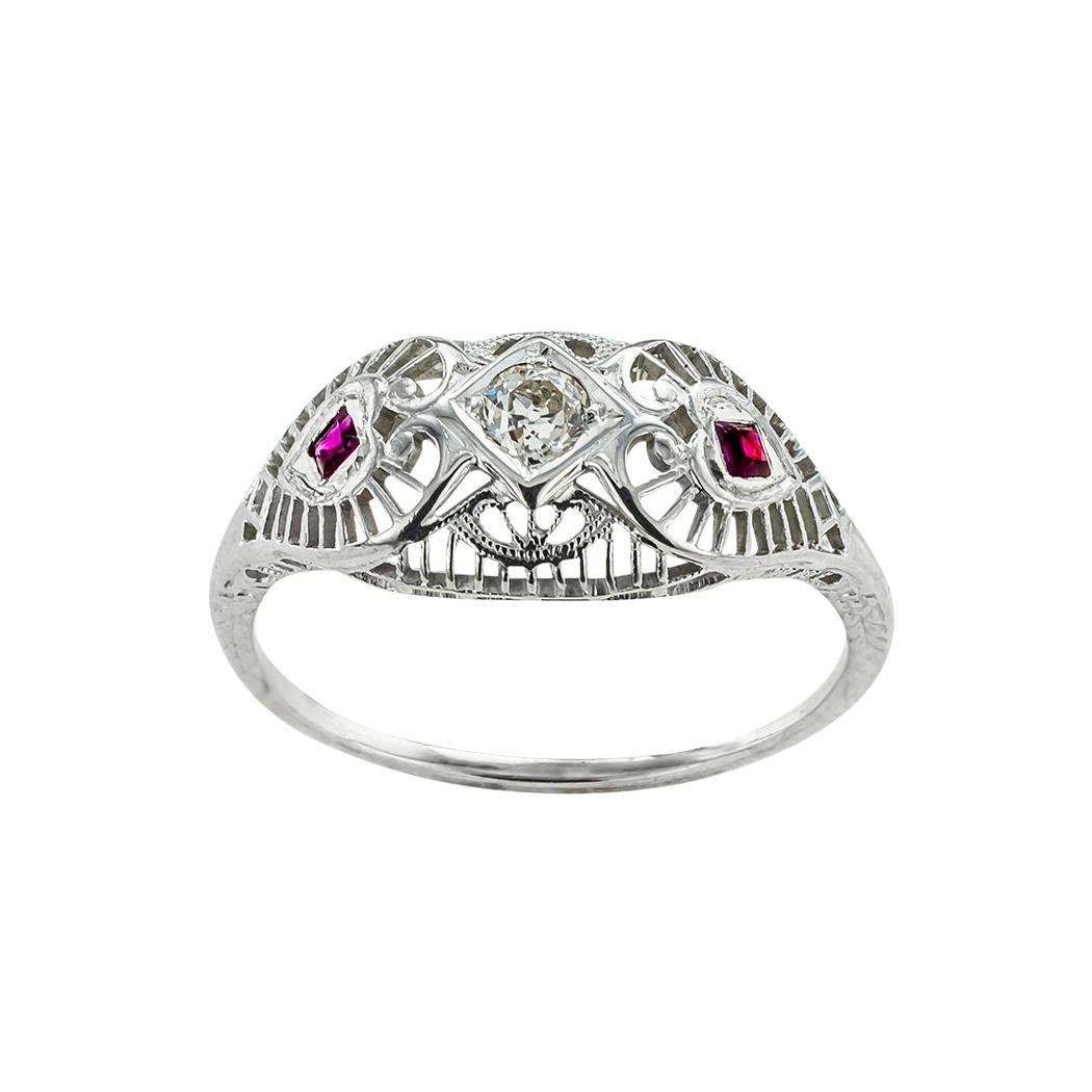 ABOUT THIS ITEM:  Here is an exciting and genuine Art Deco engagement ring that is literally loaded with beautiful and intricate filigree details.  Although the petite design is slightly domed, it has a low profile.  The ruby-set