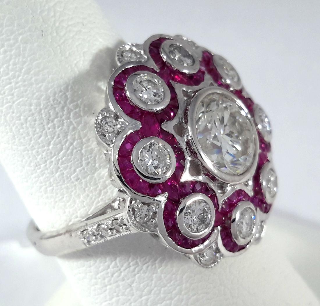This striking vintage-inspired ring is a bold celebration of color, craftsmanship, and brilliance. At the center is a 1.51-carat round brilliant diamond, graded K color and SI3 clarity, surrounded by a dazzling halo of calibré-cut rubies and