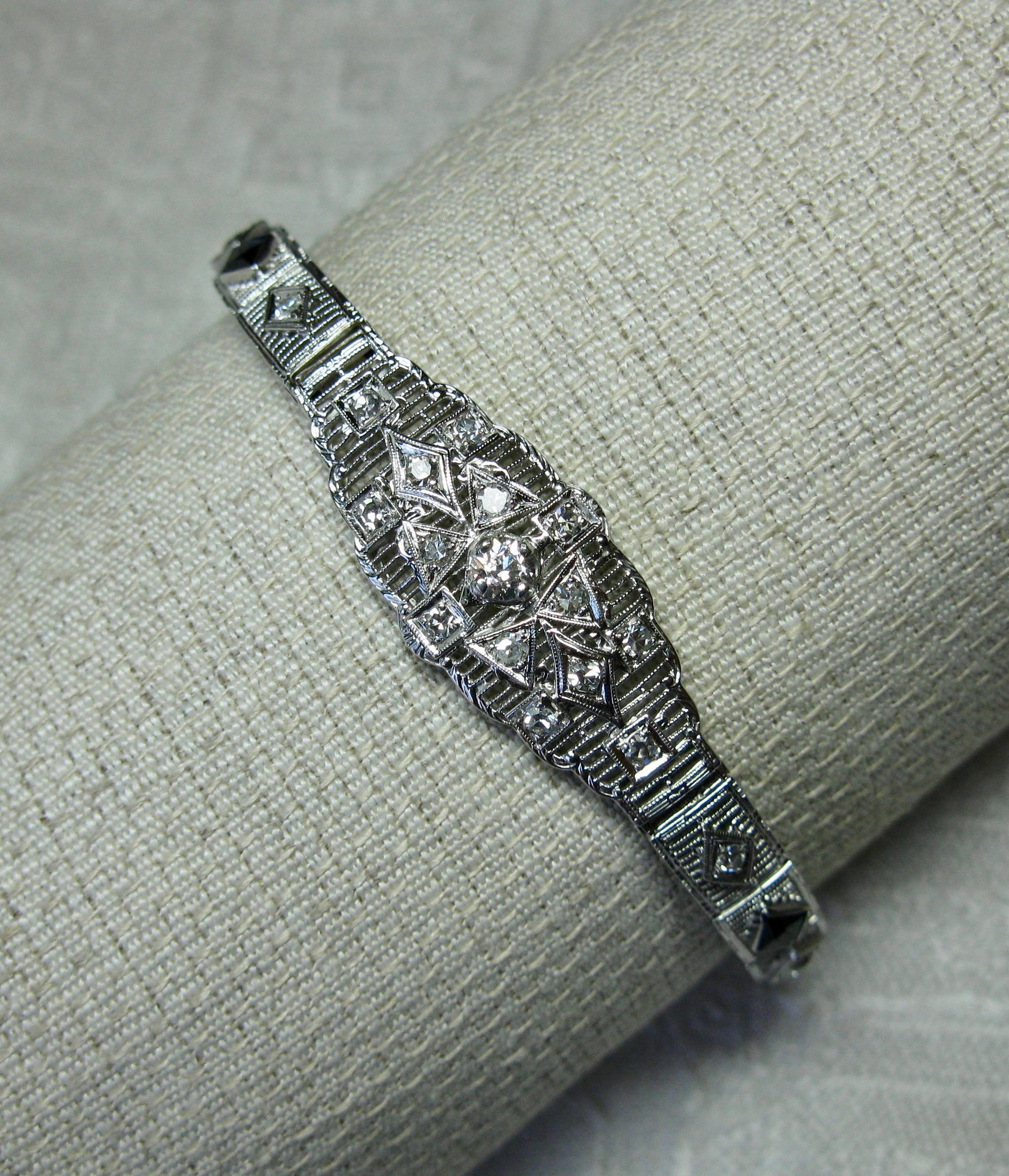 A stunning antique Art Deco Bracelet with extraordinary Deco design set with 29 high quality Diamonds totaling approximately 1.25 Carats and two fancy cut Sapphires.  The central diamond is a .20 Carat Old Mine Cut Diamond of very white H color, and