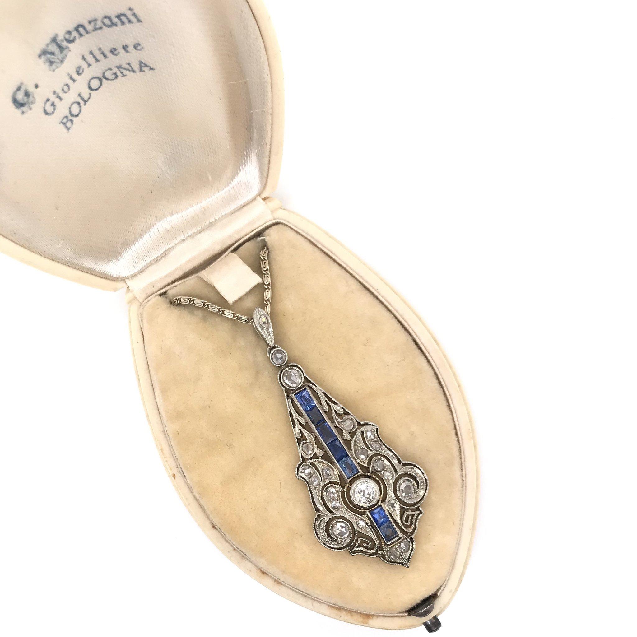 This antique piece was handcrafted sometime during the Art Deco design period ( 1920-1940 ). This exquisite antique necklace features a platinum, sapphire, and diamond pendant on a custom antique 14k white gold chain. The platinum pendant features