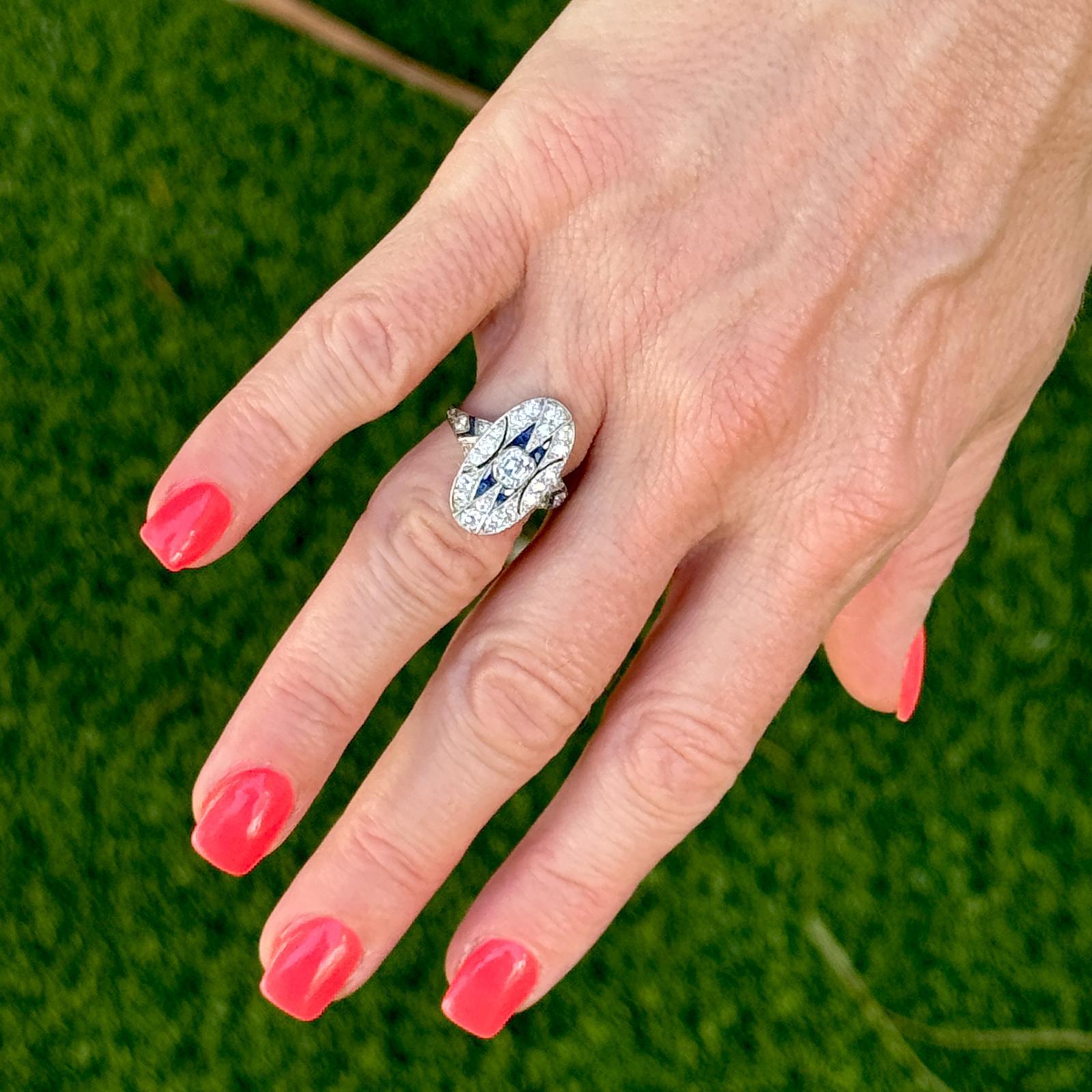 This exquisite Art Deco cocktail ring is a stunning embodiment of the period's signature elegance and geometric precision, crafted in luxurious platinum. The ring features an eye-catching oval shape design, showcasing a central .40 carat Asscher cut