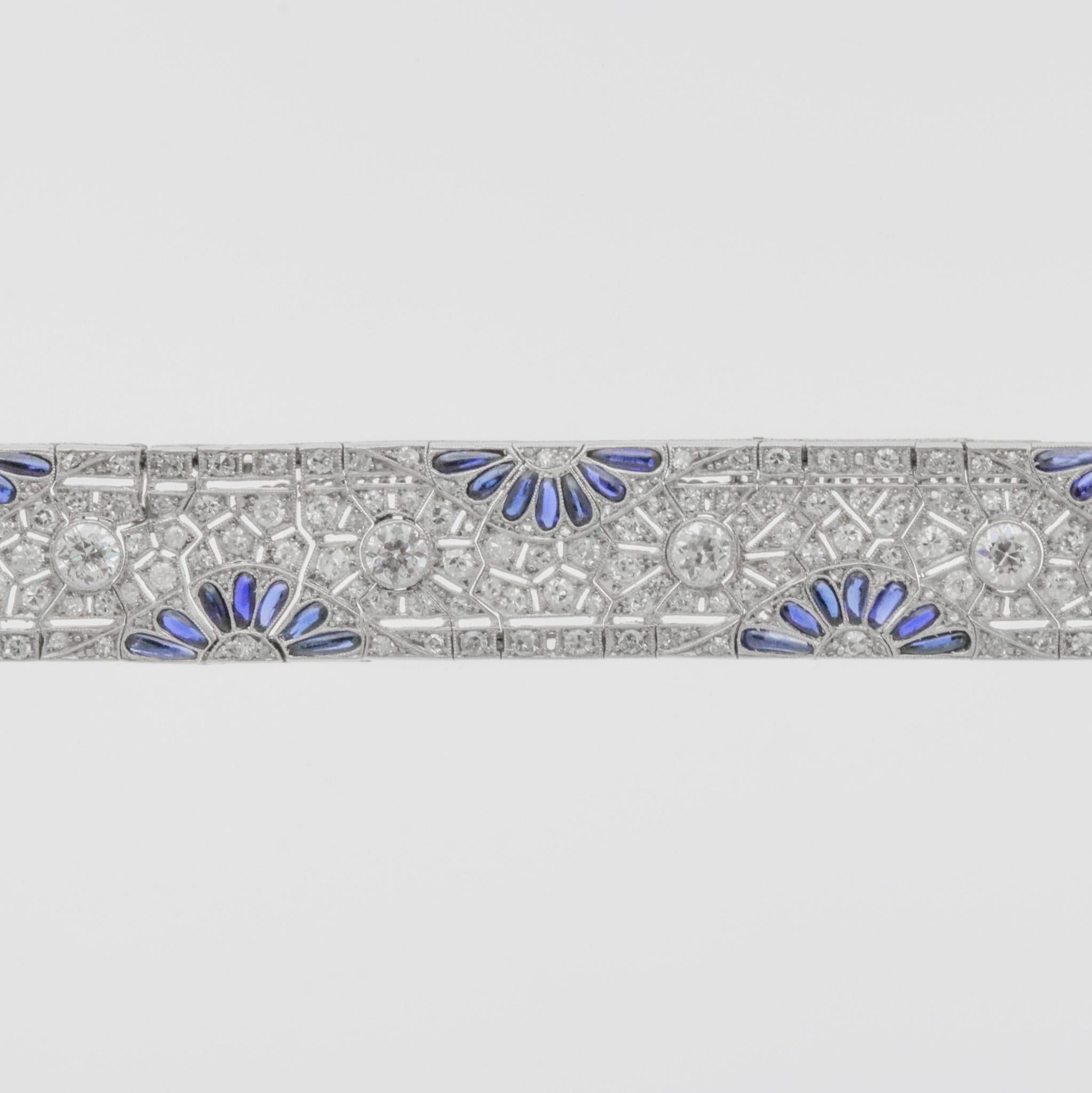 A stunning bracelet from the popular Art Deco era, circa 1920’s. It features approximately 7 carats of round European-cut and single-cut diamonds set across the piece in a geometric style. They are accented by sprays of blue sapphires adding color
