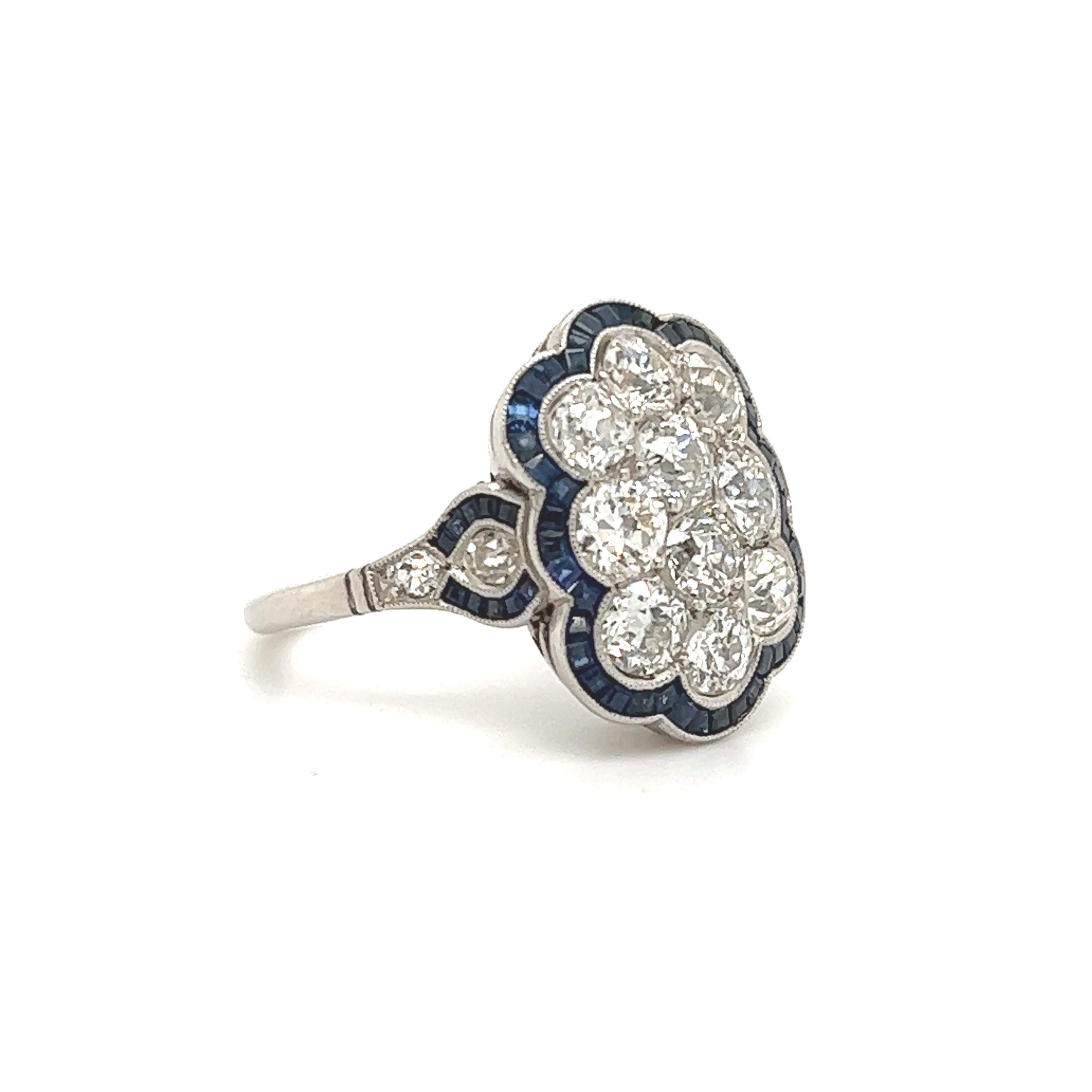 Fantastic design seen on this Art Deco treasure. This ring is crafted in platinum. The ring is set with old European cut diamonds and vivid blue sapphires in baguette shape.  The diamonds in the design are set in a honeycomb pattern, with each