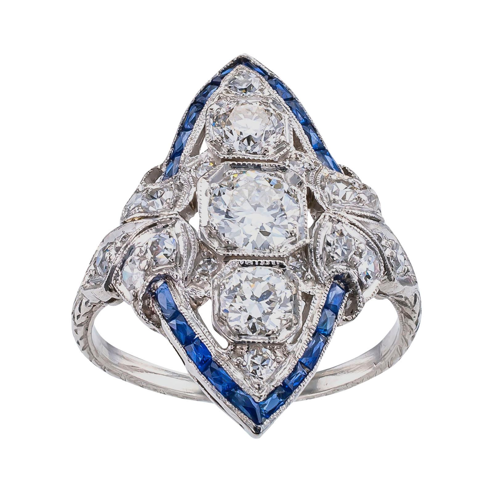 Art Deco diamond sapphire and platinum dinner ring circa 1925.

DETAILS:

DIAMONDS: nineteen old-cut circular diamonds totaling approximately 1.20 carats, approximately H – J color and VS – SI clarity.

GEMSTONES: French-cut blue sapphires.

METAL:
