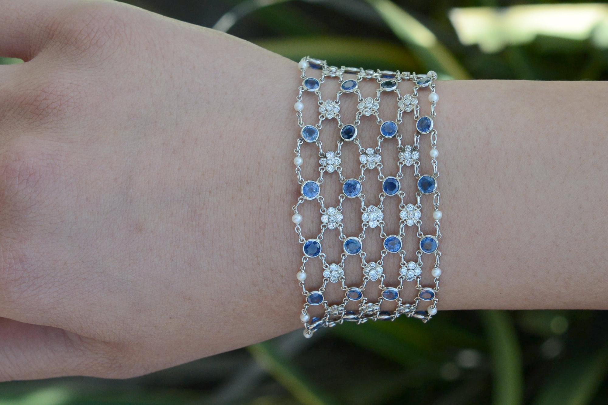 Featuring rows of bright blue sapphires, radiant diamonds, and creamy seed pearls, this platinum mesh bracelet is the epitome of Art Deco bliss. The floral clusters of diamonds stationed between velvety blue sapphires and the dreamy pearls lining