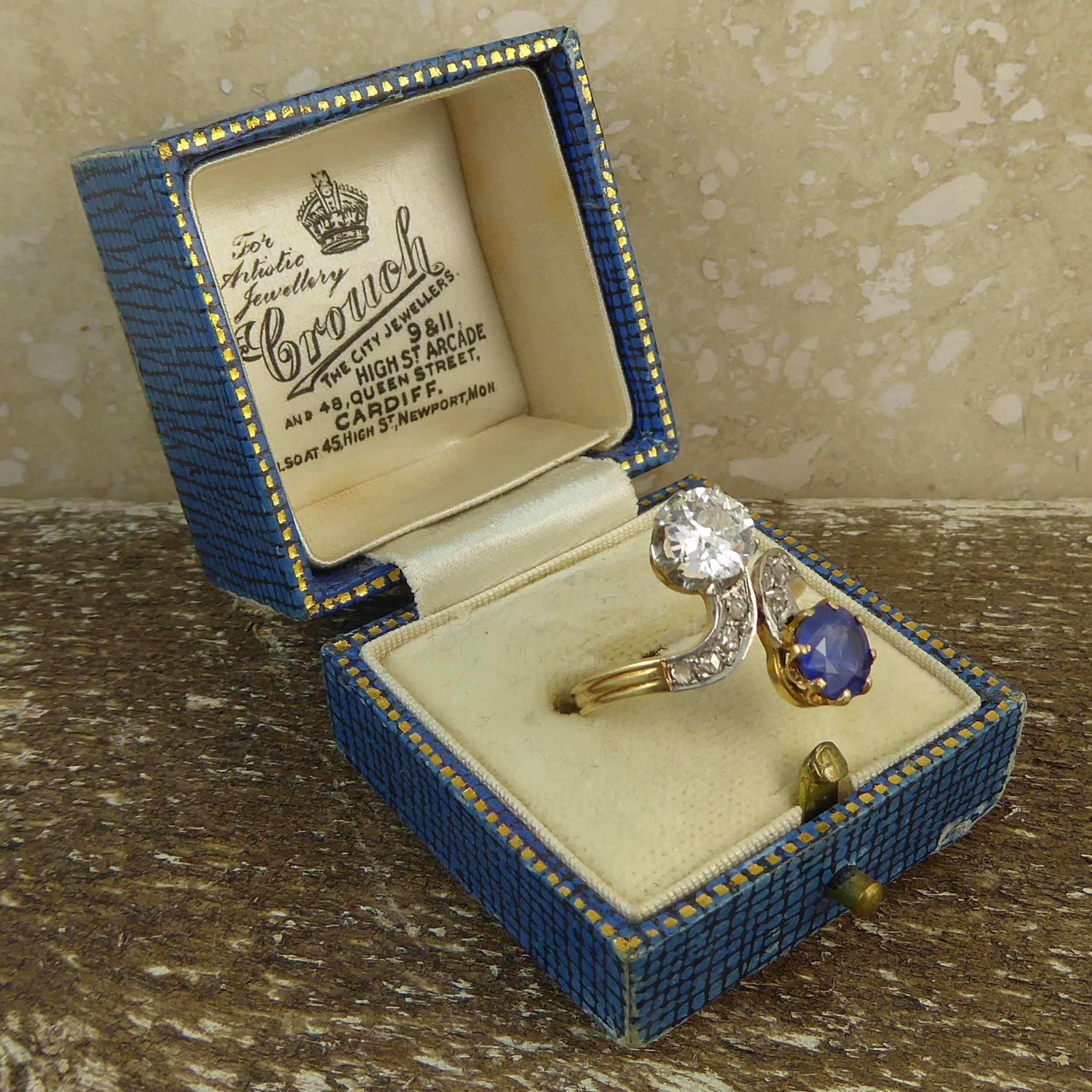 A vintage diamond and sapphire cross over ring (Toi et Moi) with diamond shoulders.   To one side of the twist is a round old cut diamond measuring approx. 6.23mm -6.26mm diameter x 3.28m deep claw set in white.  The diamond is calculated to weigh