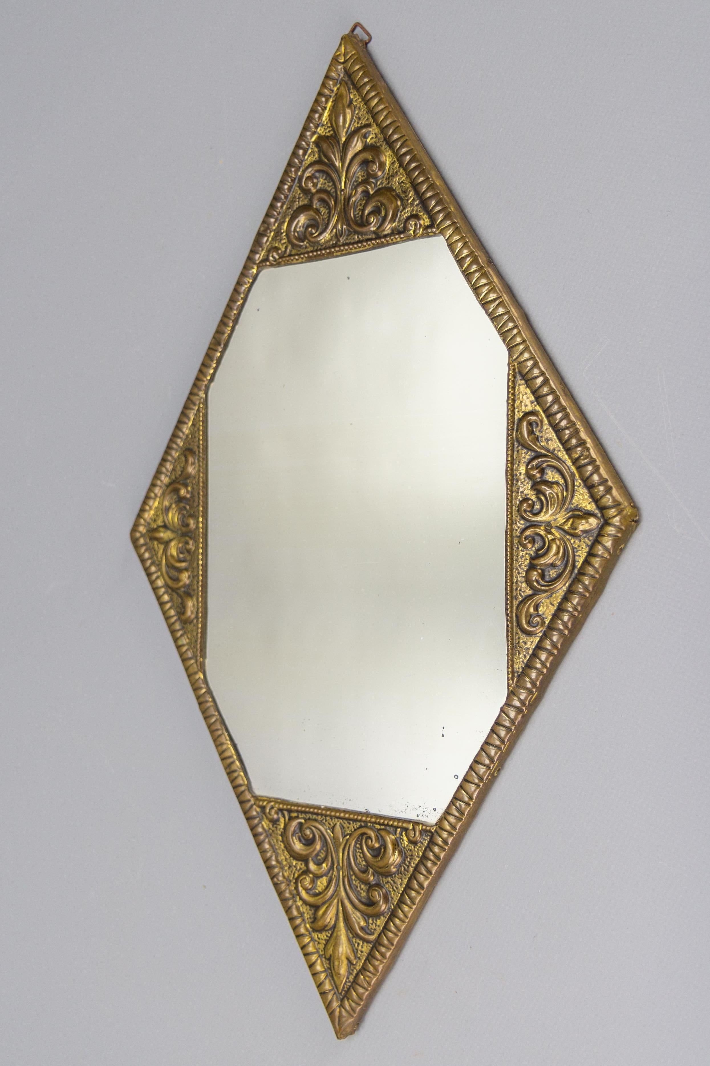Art Deco diamond-shaped brass frame wall mirror, from ca. 1920.
This adorable Art Deco period diamond - or rhombus-shaped wall mirror features an ornate brass frame and wooden backside.
Dimensions: height: 41 cm / 16.14 in; width: 24 cm / 9.45 in;