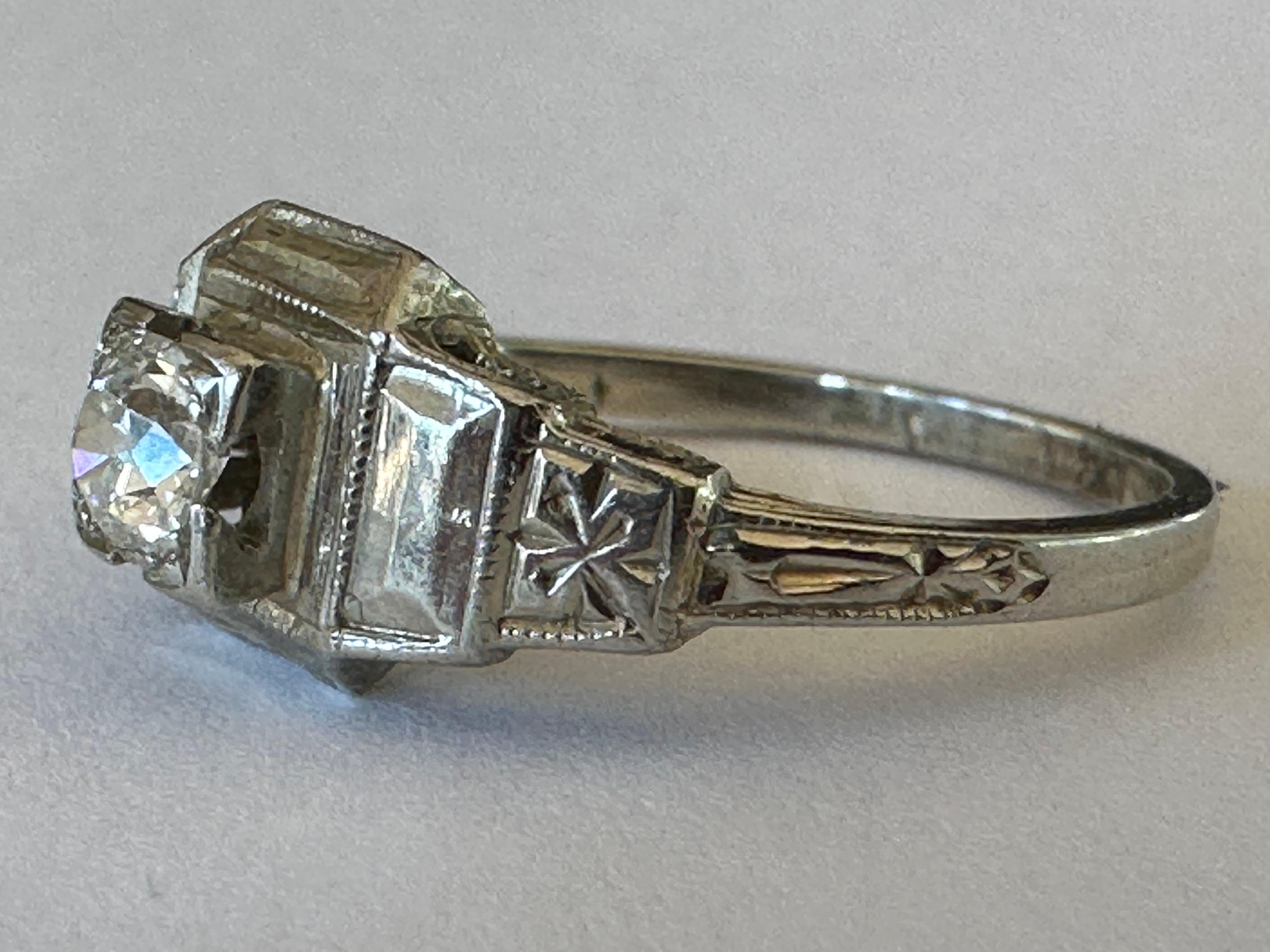 An approximately 0.30-carat Old European cut diamond centers this antique Art Deco ring, IJ color, VS clarity, complemented with hand-engraved shoulders and fine millegrain edging. Handcrafted in 18K white gold. 