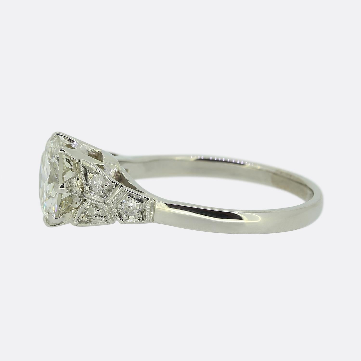 Here we have a lovely diamond engagement ring dating back to the Art Deco era. The ring plays host to a single round brilliant cut diamond that sits in an 8 clawed mount. It is crafted in platinum and features a further three diamonds on each