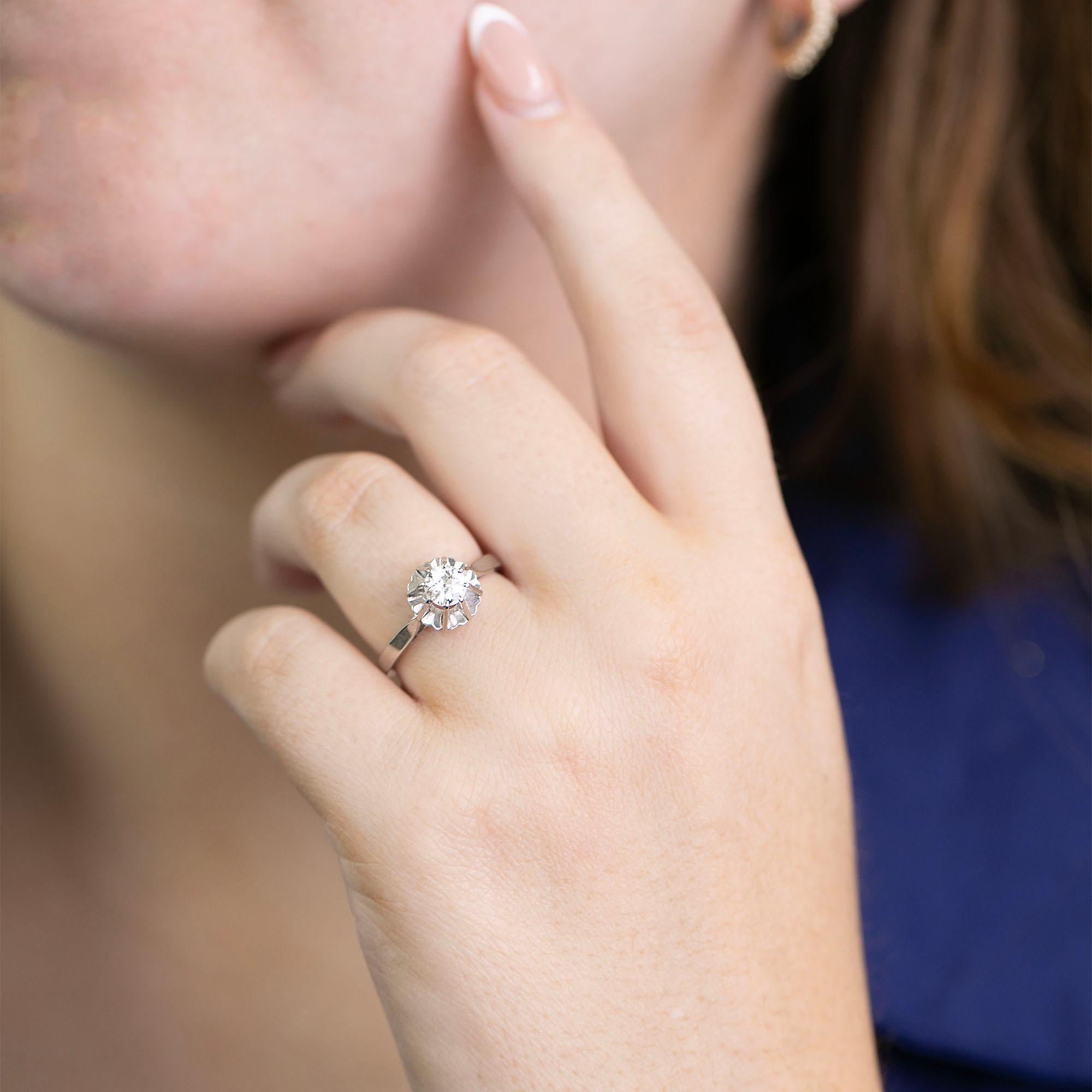 True to its era this French made Art Deco diamond ring is crafted in platinum and 18k white gold. This solitaire ring features a high eight claw coronet setting set with a early European cut diamond. Fitted within the shank are internal stabilising