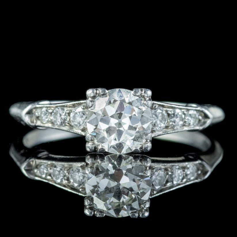 A stunning Art Deco solitaire ring from the early 20th Century crowned with a beautiful old European cut diamond weighing approx. 0.80ct. It has excellent SI1 clarity – H colour and is accompanied by three brilliant cut diamonds running down each