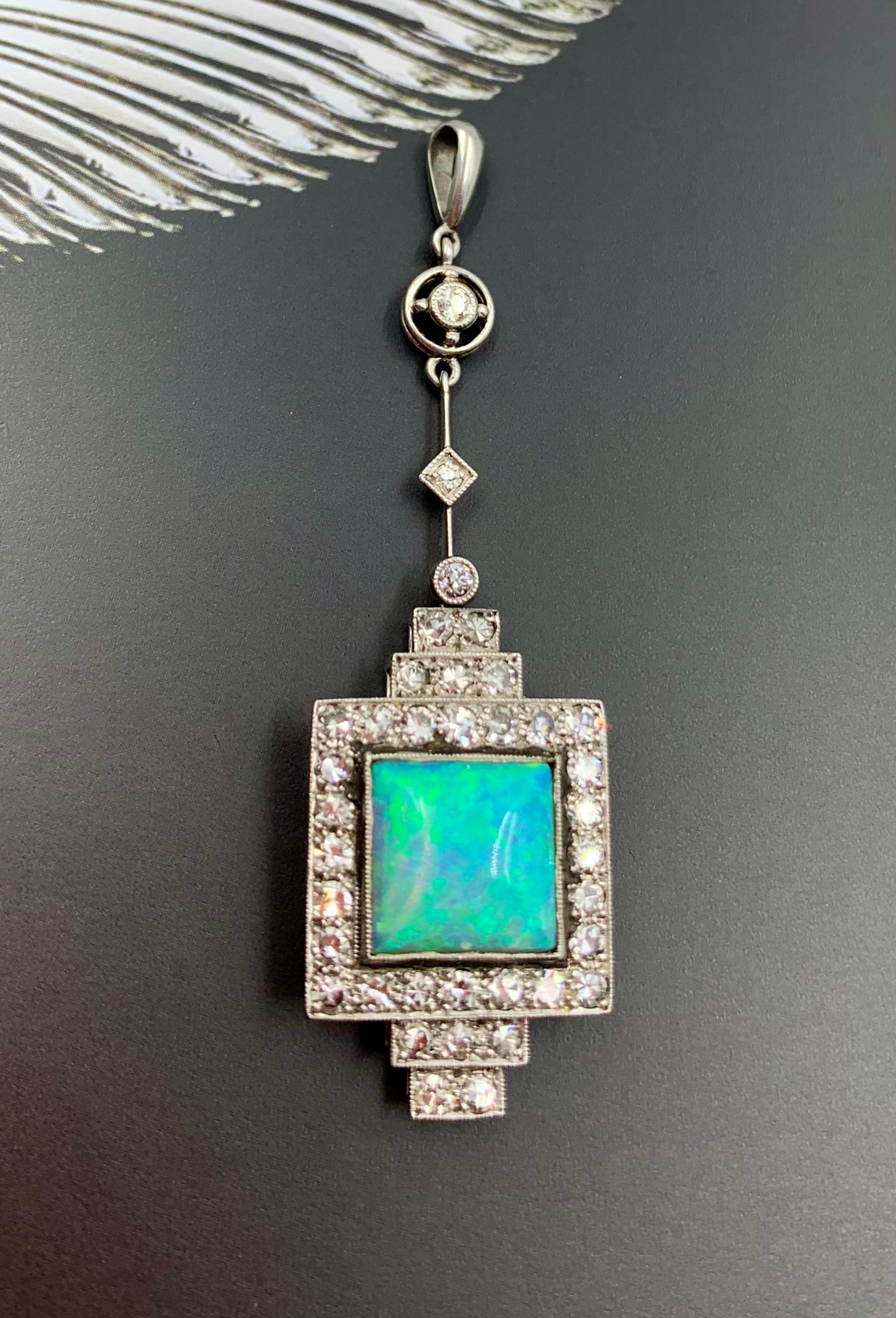 Pendentif Art déco en diamant, opale bleu-vert cabochon de taille carrée et or blanc et jaune 18 carats.
Début du 20e siècle
Exquis et élégant pendentif en or blanc 18 carats de la période Art déco, orné de diamants et d'opales bleu-vert. L'opale