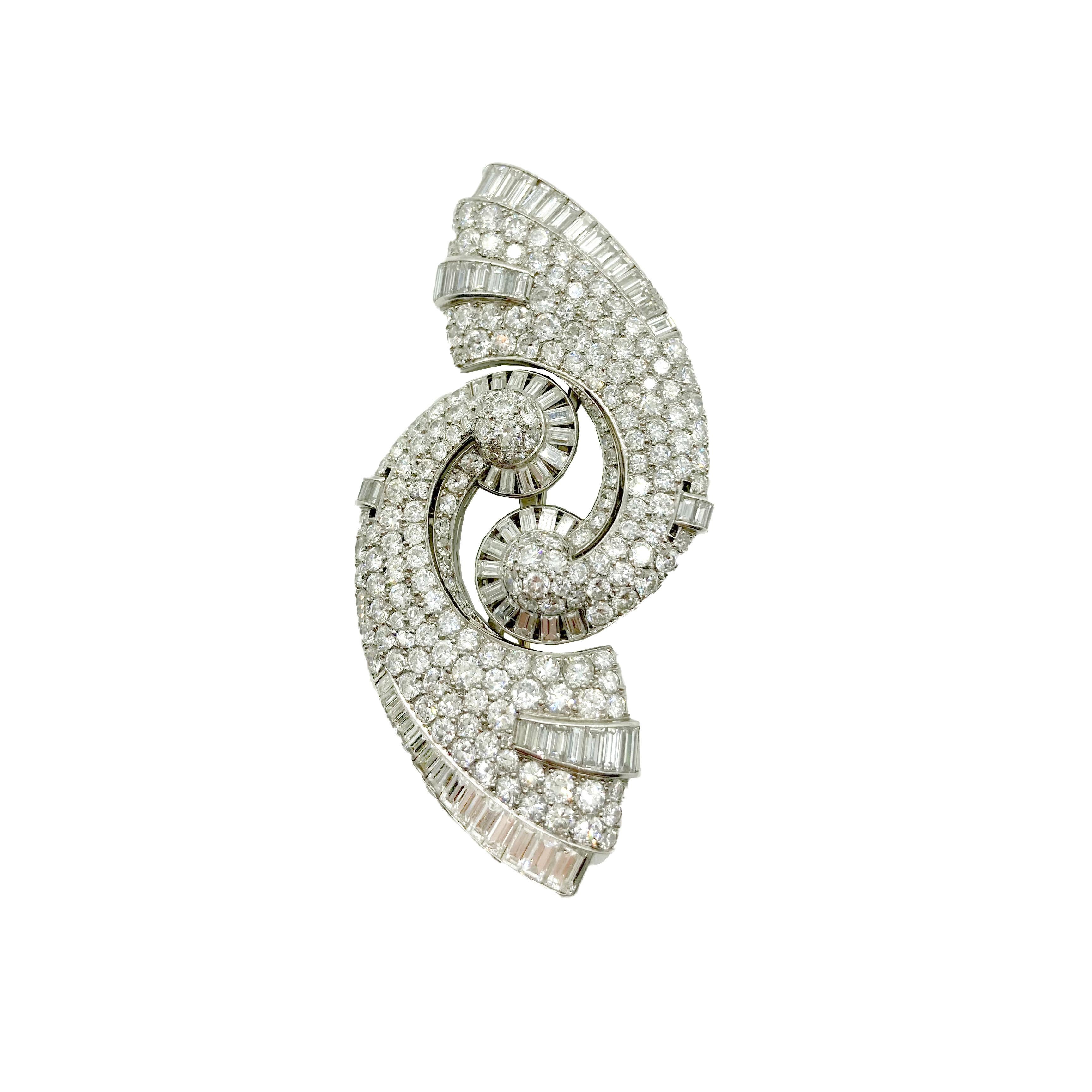 A beautiful Art Deco brooch featuring swirls of diamonds. Can be divided and worn as a pair of dress clips. Circa 1920s.