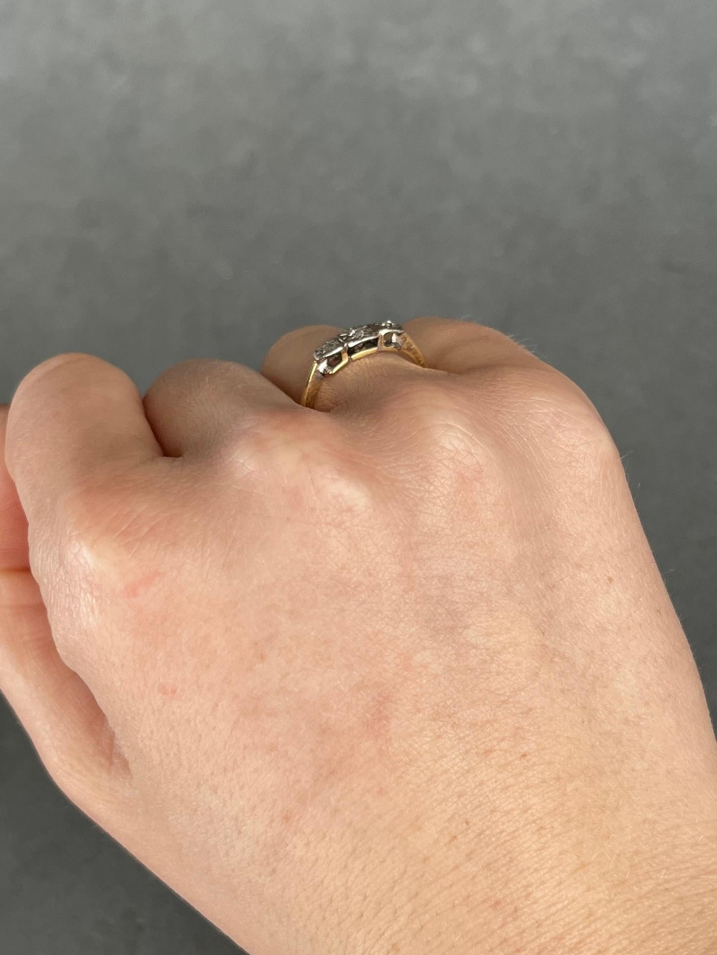 Three diamonds sit fabulously on top of a simple setting modelled in 18ct gold and stones set in platinum. The central round diamond measures 7pts and the rose cut diamonds either side measure 4pts each.  

Ring Size: L or 5 3/4 
Height Off finger: