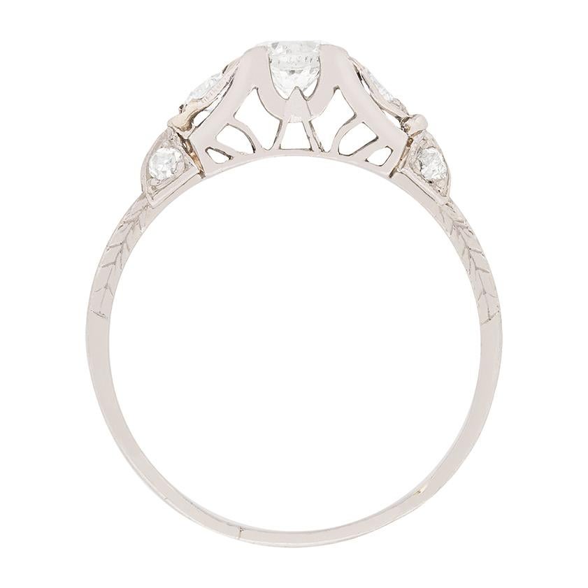 Dieser Ring stammt aus den 1920er Jahren und hat als Hauptattraktion drei Diamanten. Der Diamant in der Mitte wiegt 0,40 Karat, die beiden schräg gefassten Diamanten an den Seiten jeweils 0,15 Karat. Auf den Schultern befinden sich auf beiden Seiten