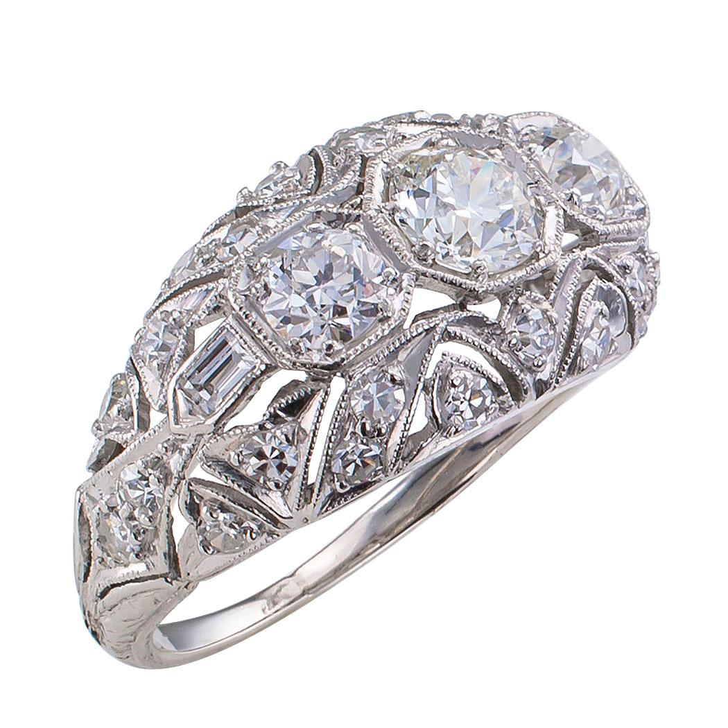 Art Deco three stone diamond and platinum ring circa 1925. The elongated and slightly domed three stone design features a trio of graduating diamonds the largest one, center, weighs approximately 0.45 carat, approximately H – I color and VS clarity,