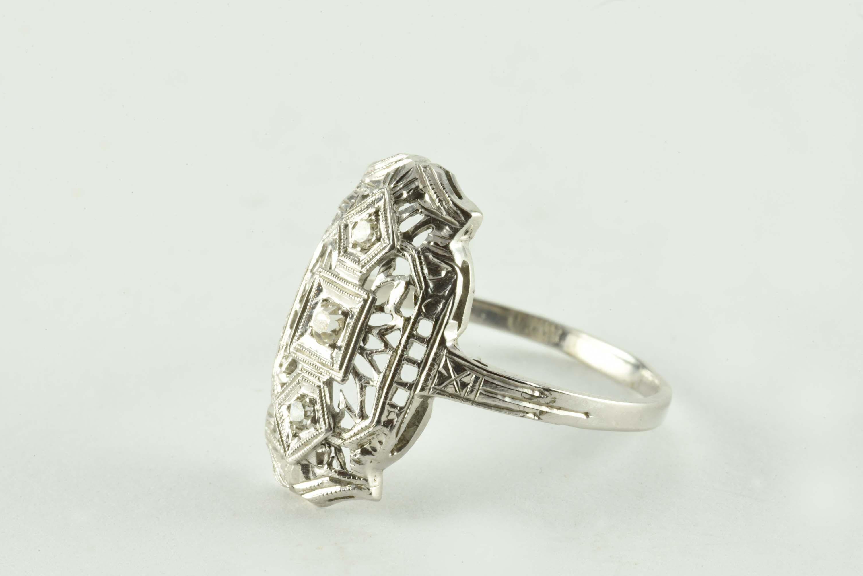 This striking antique band is meticulously crafted from 14kt white gold with fine filigree details and set with a trio of single cut diamonds H-I color, SI clarity, totaling 0.10 carats. 
