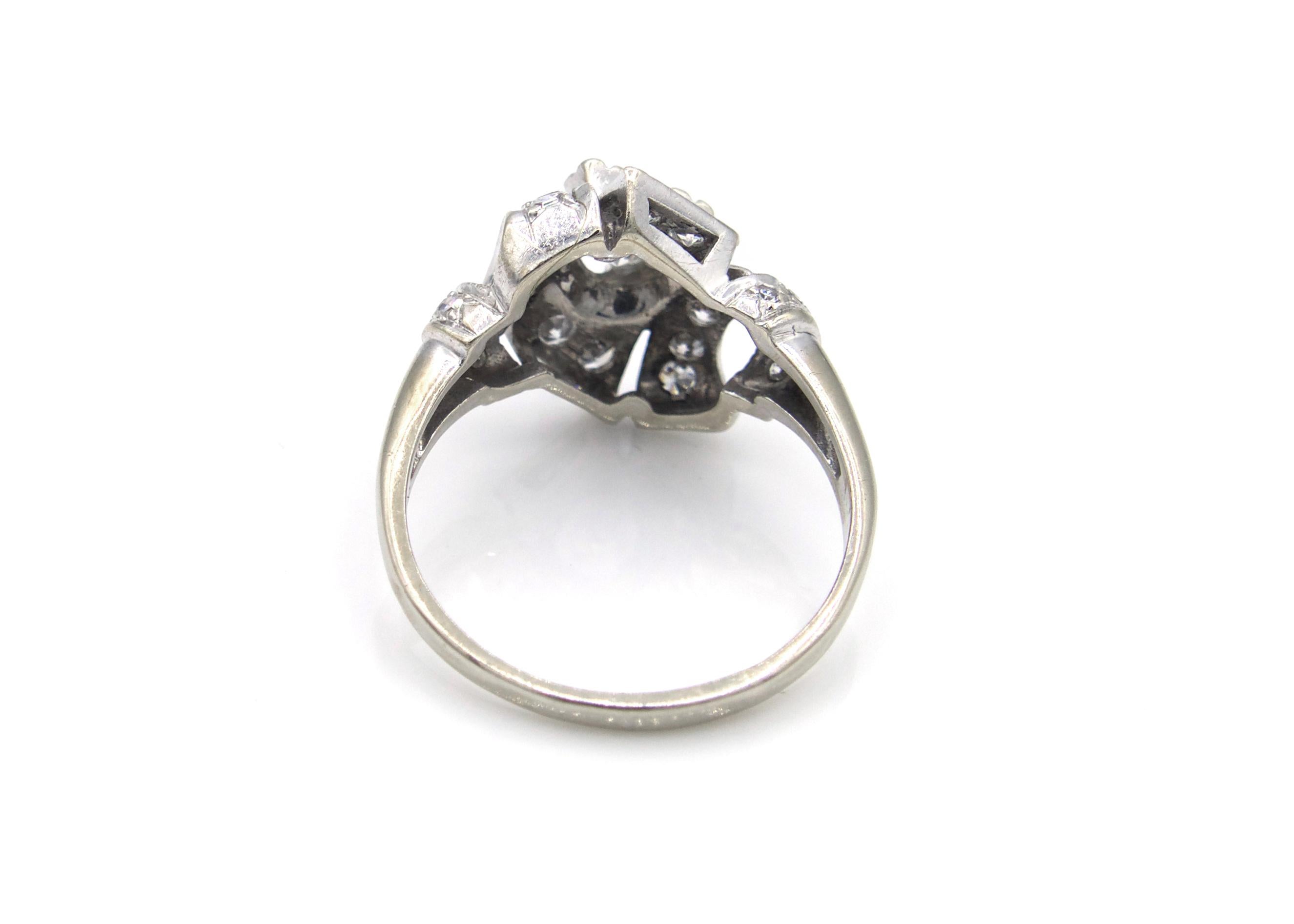 This lovely Art Deco engagement ring is centrally set with a 0.50 Carat center Diamond surrounded by another 0.50 carats of sparkling white diamonds. The 14K White Gold setting has a beautiful ribbon-like shape that surrounds the center stone. 

 
