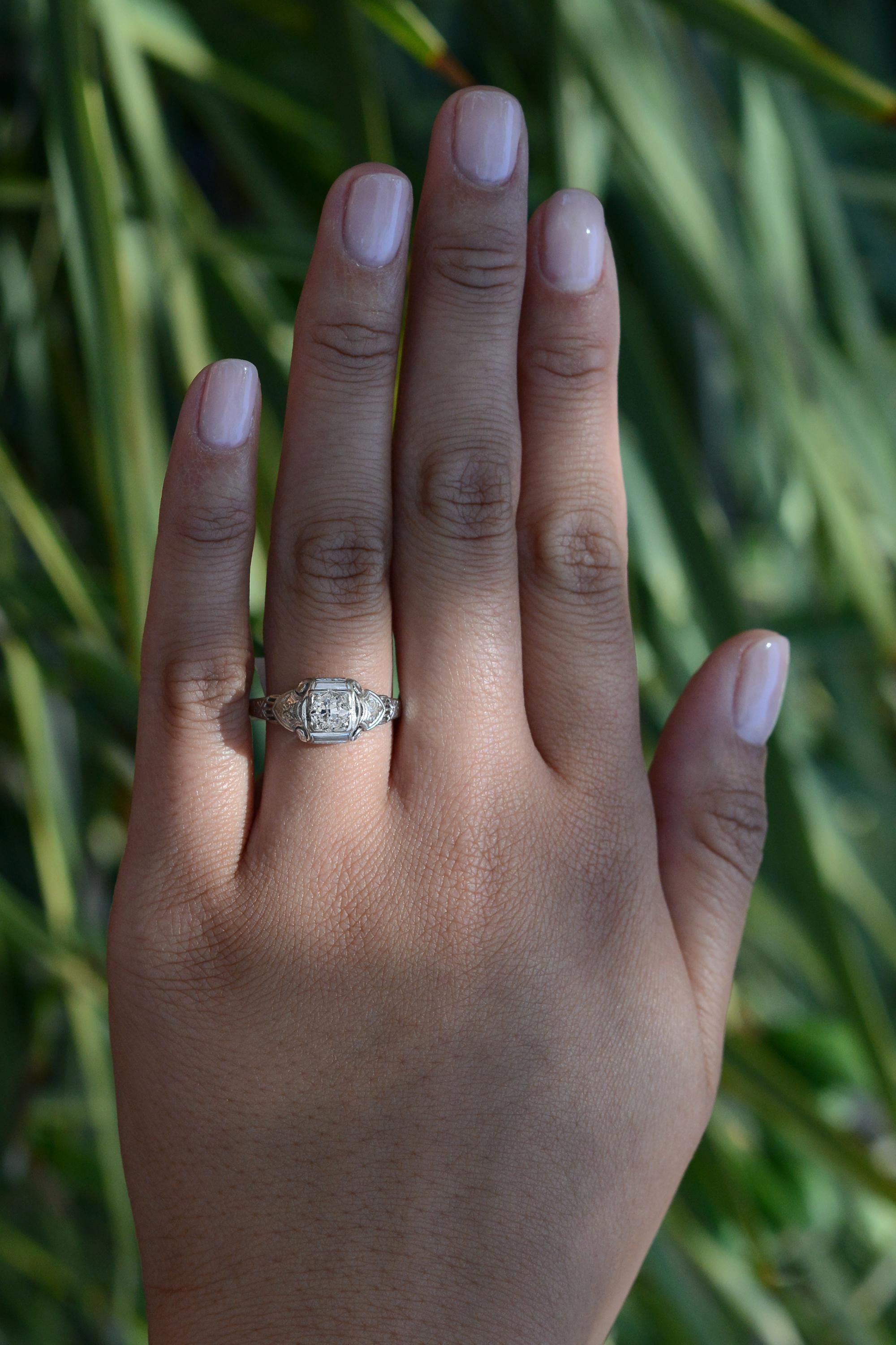A vintage, affordable Art Deco engagement ring, a 1920s antique heirloom; ideal for that momentous proposal. Boasting a sparkling, 1/3 carat old European diamond, the near colorless gem presented in a hand engraved mount. Handcrafted with 18 karat