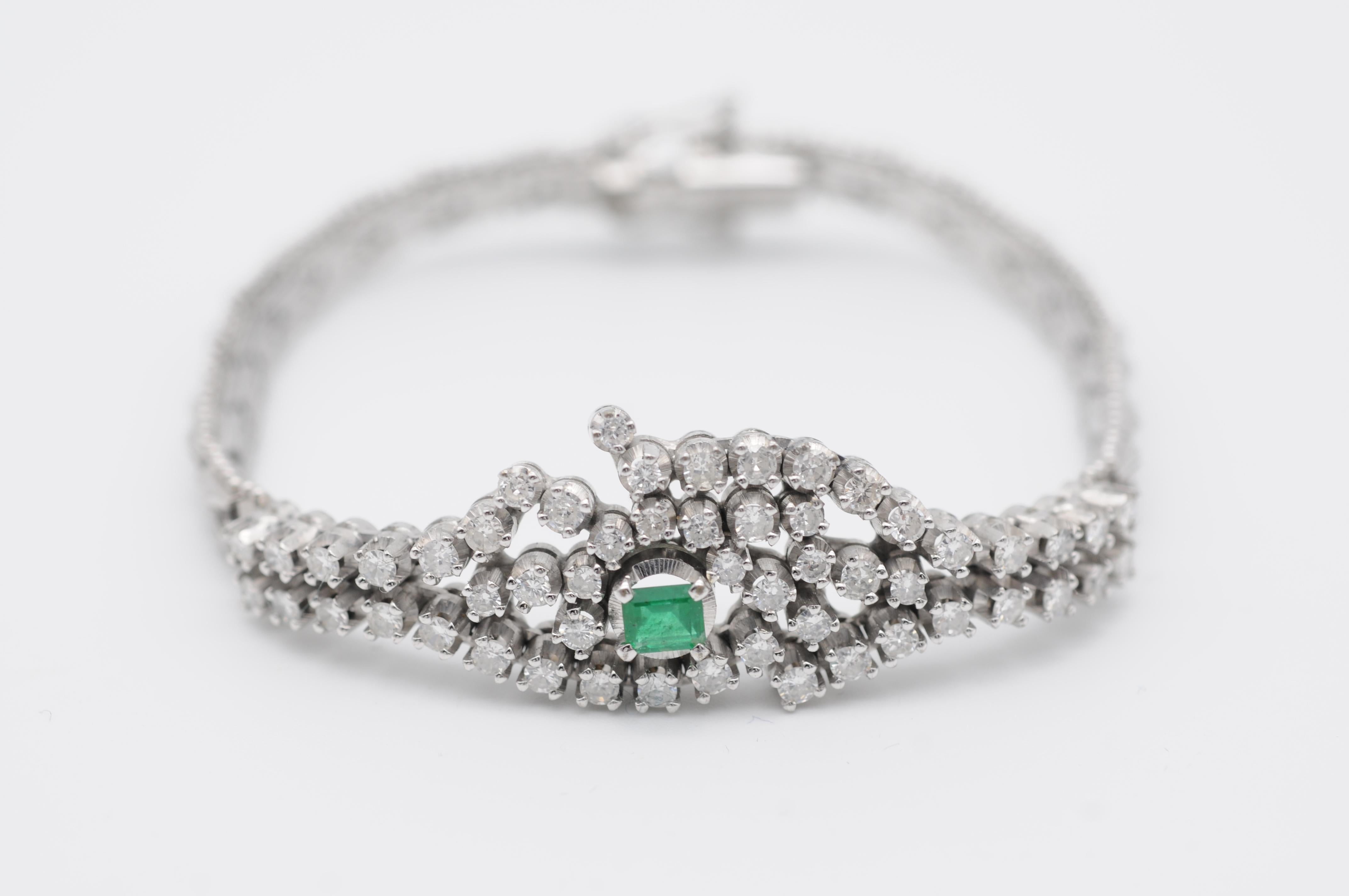 Indulge in the luxurious elegance of this 18k white gold bracelet, adorned with a breathtaking emerald stone and a cascade of 56 brilliant-cut diamonds that sparkle and shine with every movement. The emerald, with a weight of approximately 0.25 ct,