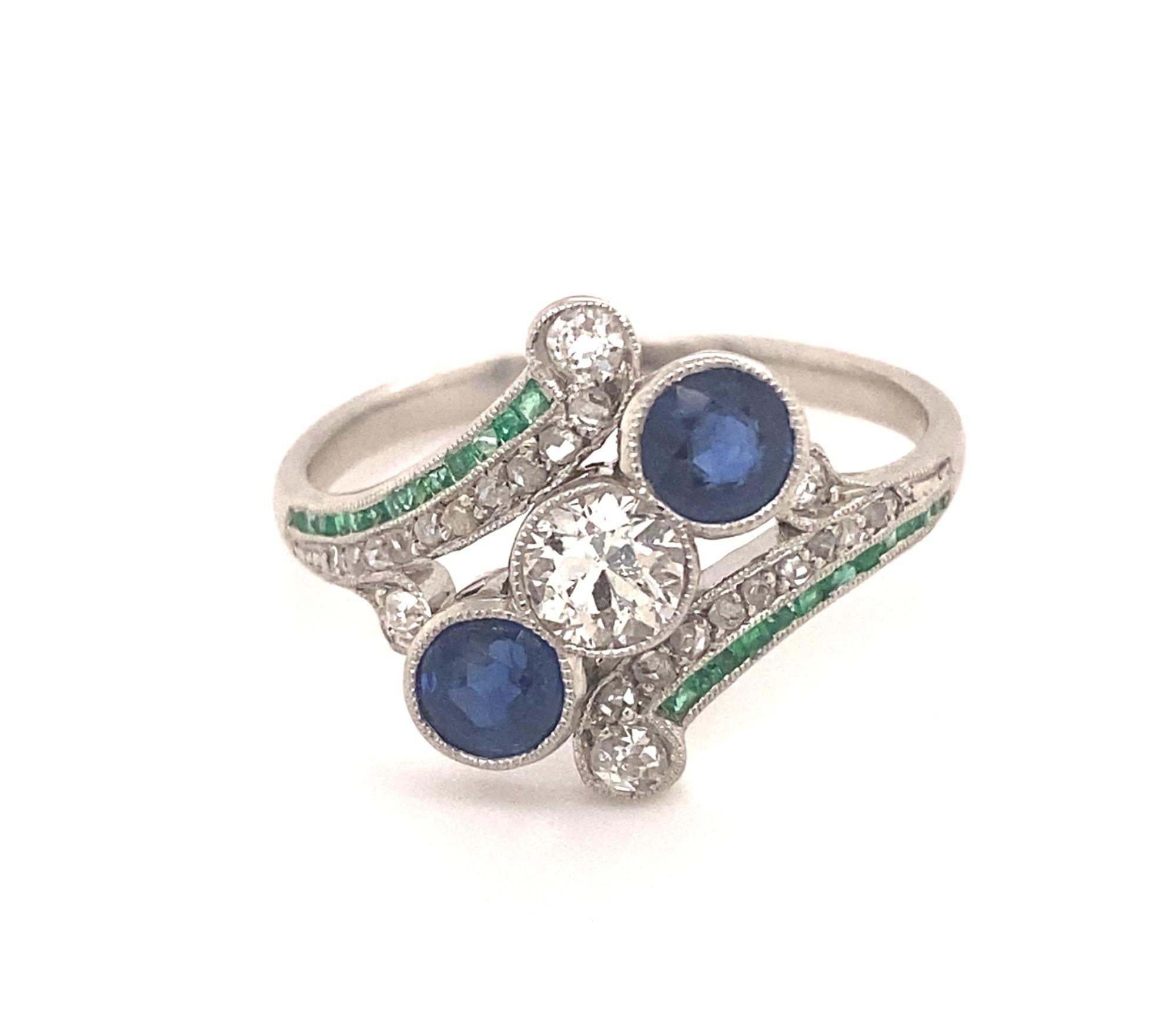 This is a beautiful original art deco ring c.1940's set in platinum. The ring is set with a European cut diamond, two round sapphires, rose cut diamonds and emeralds. The center diamonds measures .40 carats I color SI-1 clarity, the two round