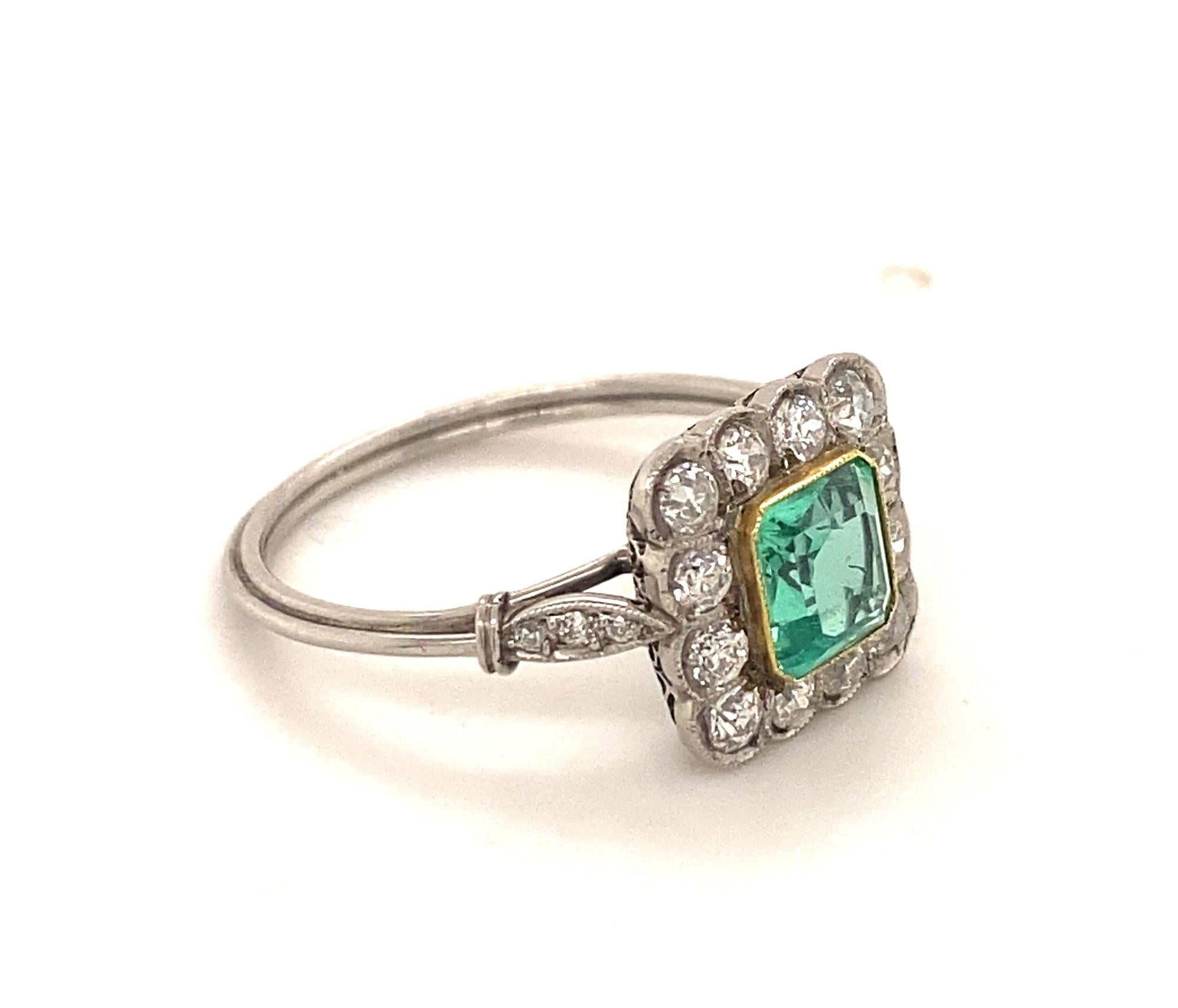 This is a beautiful art deco Style ring set with a stunning light green emerald old mine cut diamonds in platinum.  The gallery of the ring has an intricate filigree design the ring shank has a three rope like design.  The emerald is natural nice