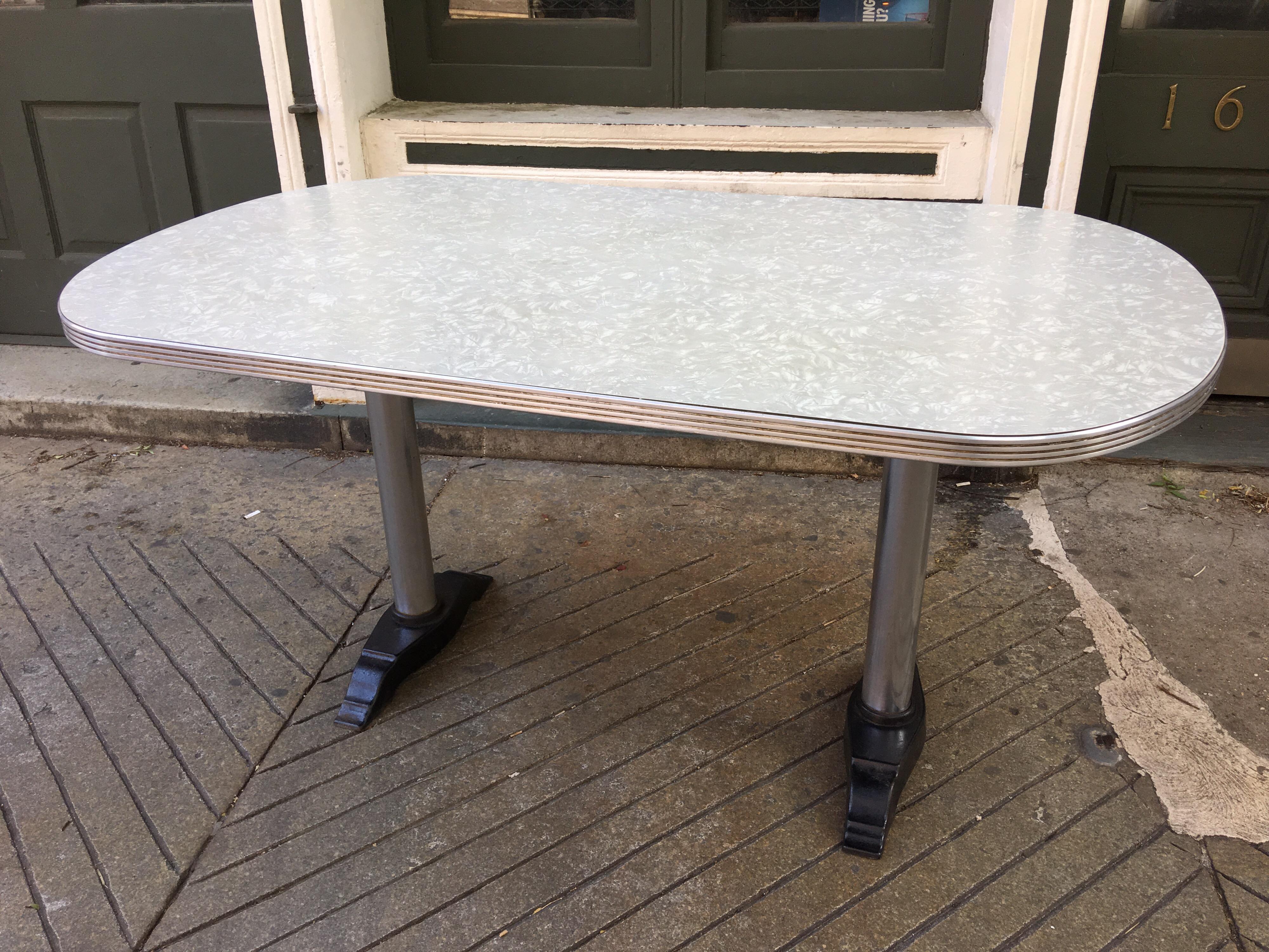 Great $0's or 50's Diner Table. 2 pedestal bases give this formica topped table style and stability! Formica in great shape! Aluminum edging with chrome poles and cast iron black feet are all classic Deco styling!